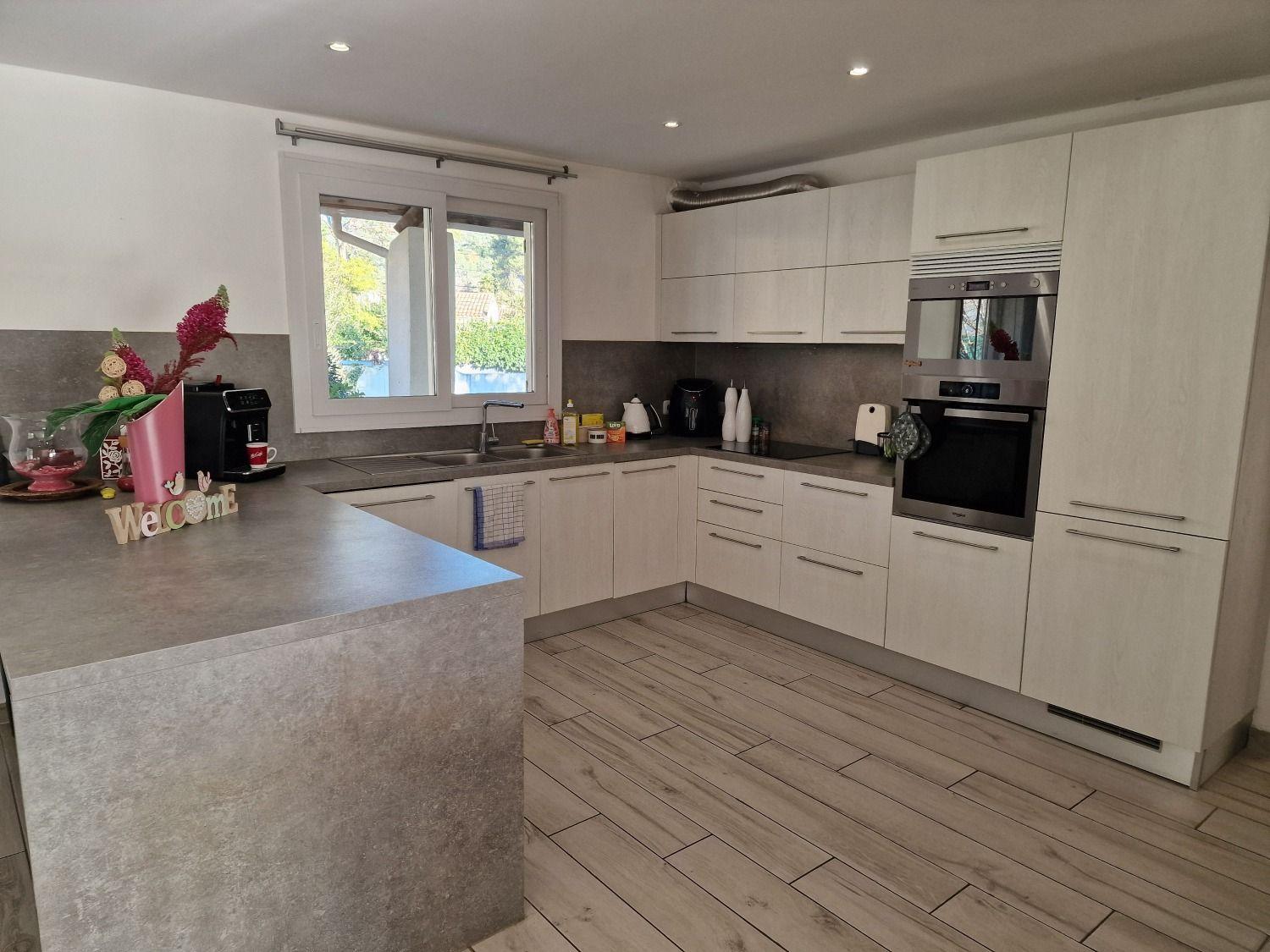 Spacious, fully equipped kitchen with modern white cabinets, appliances, and a kitchen island with a 'Welcome' sign