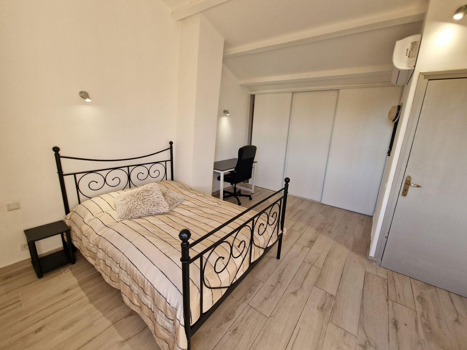 Room Cannes with a queen-size bed with iron frame, wardrobe, and desk with office chair