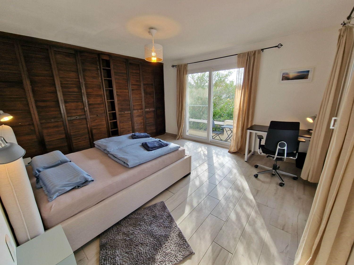 Room Antibes with a double bed, large wooden wardrobe, and sliding door to private terrace