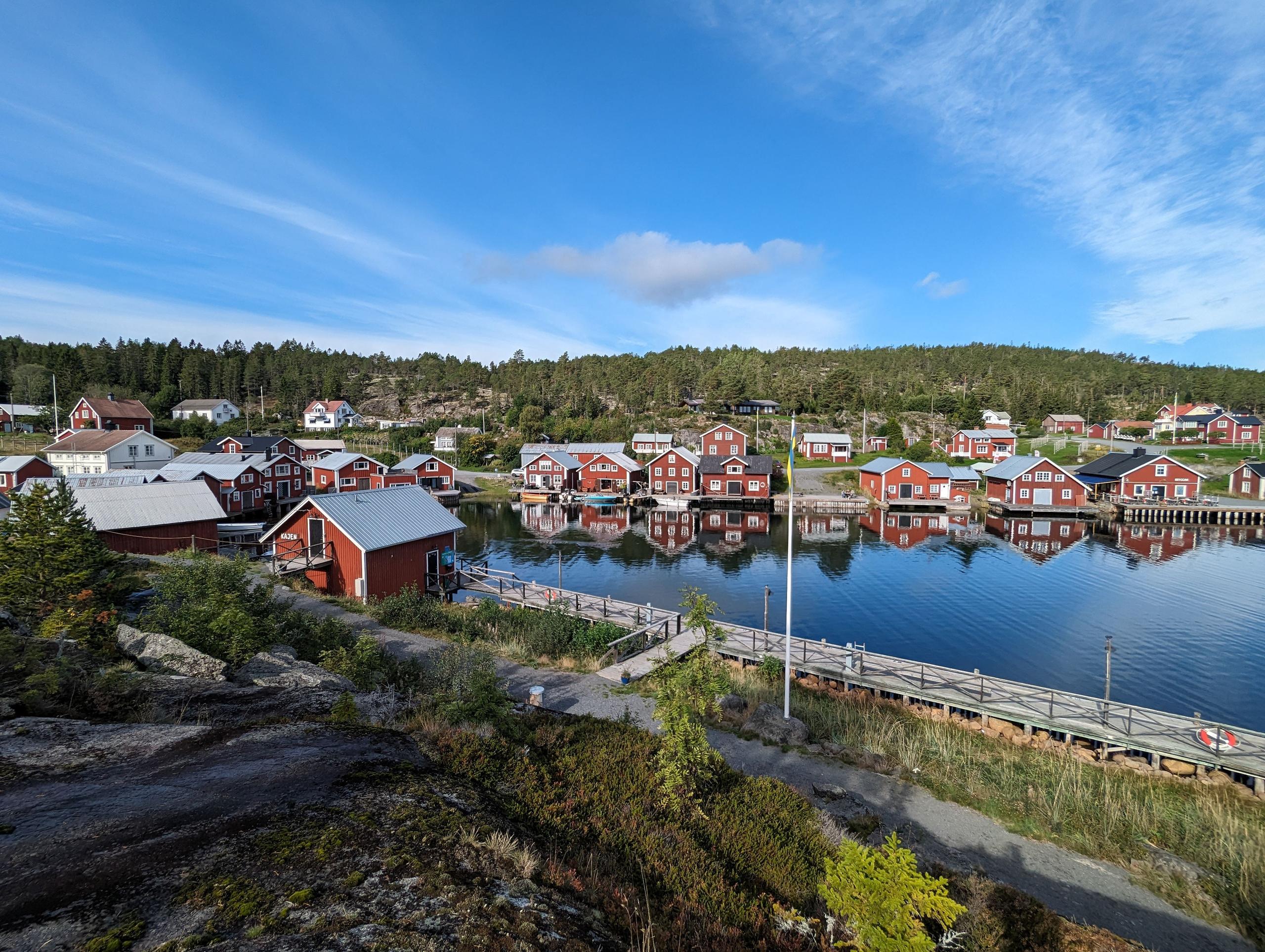 Red-housed fishing village with boats and reflections on the water in the Höga Kusten region