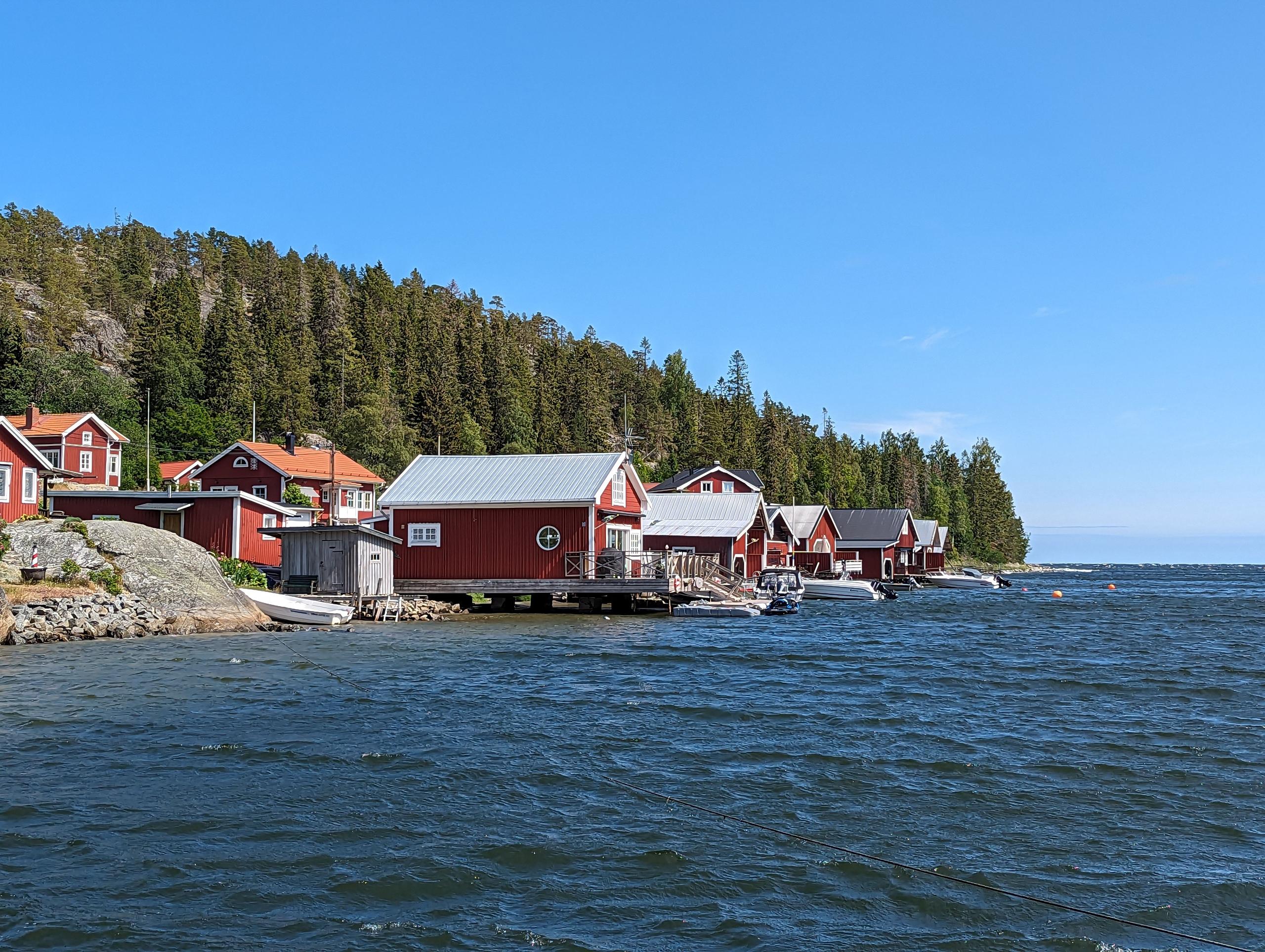 Fisher village in Härnösand with red houses and boats along the waterfront