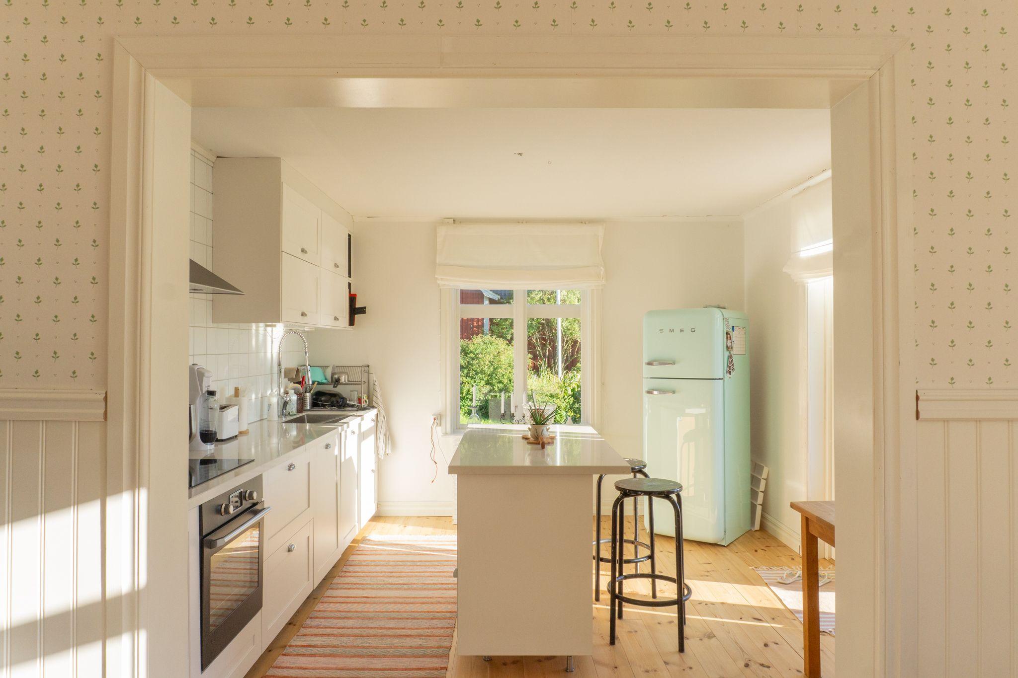 Bright private bedroom with a bed, desk, office chair and plants