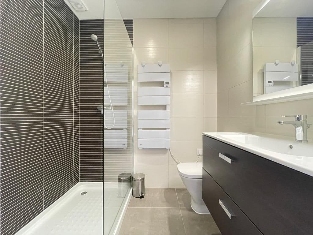 Private bathroom with walk-in shower and heated towel rack in the Ensuíte Cantinho
