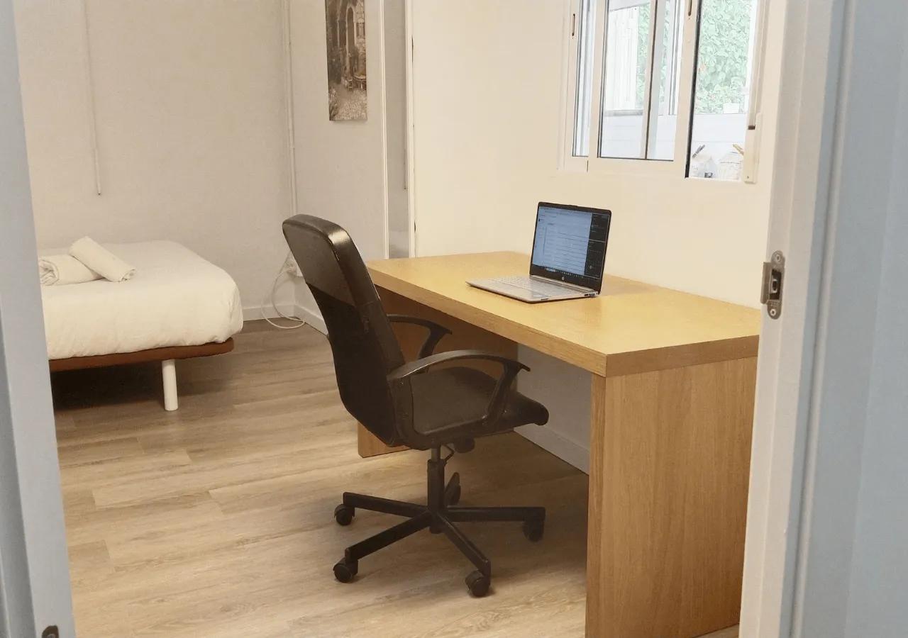 Double bedroom Isla showing the spacious office area with a large desk and ergonomic chair, with the bed visible in the background
