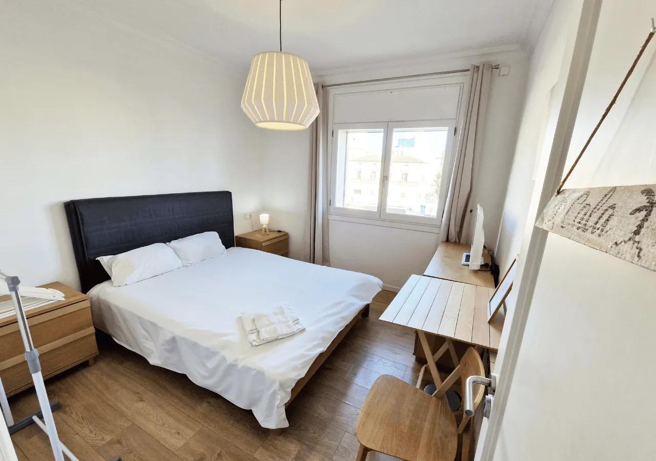 Comfortable private double bedroom Cala with a double bed, desk, and natural light from the window
