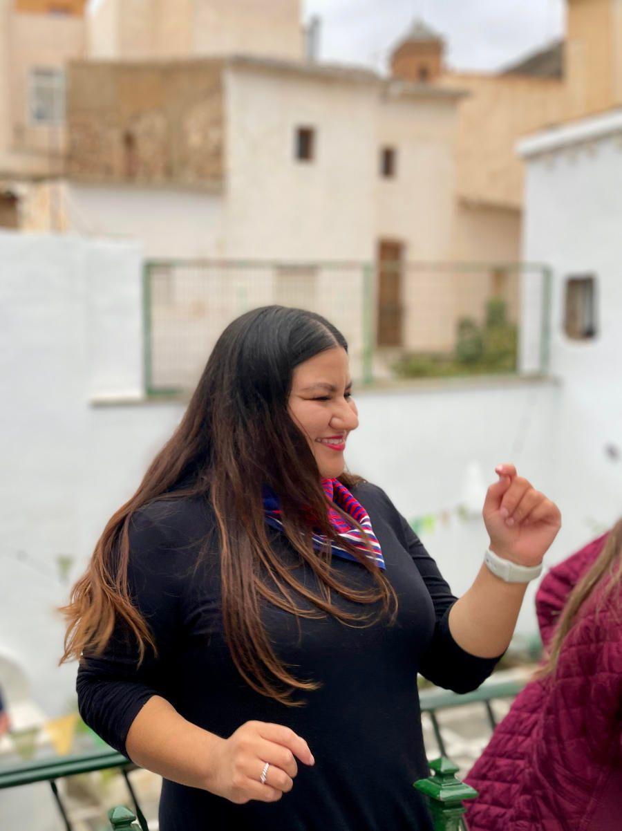 A woman on the terrace with the Purchena village rooftops and a church tower visible in the background
