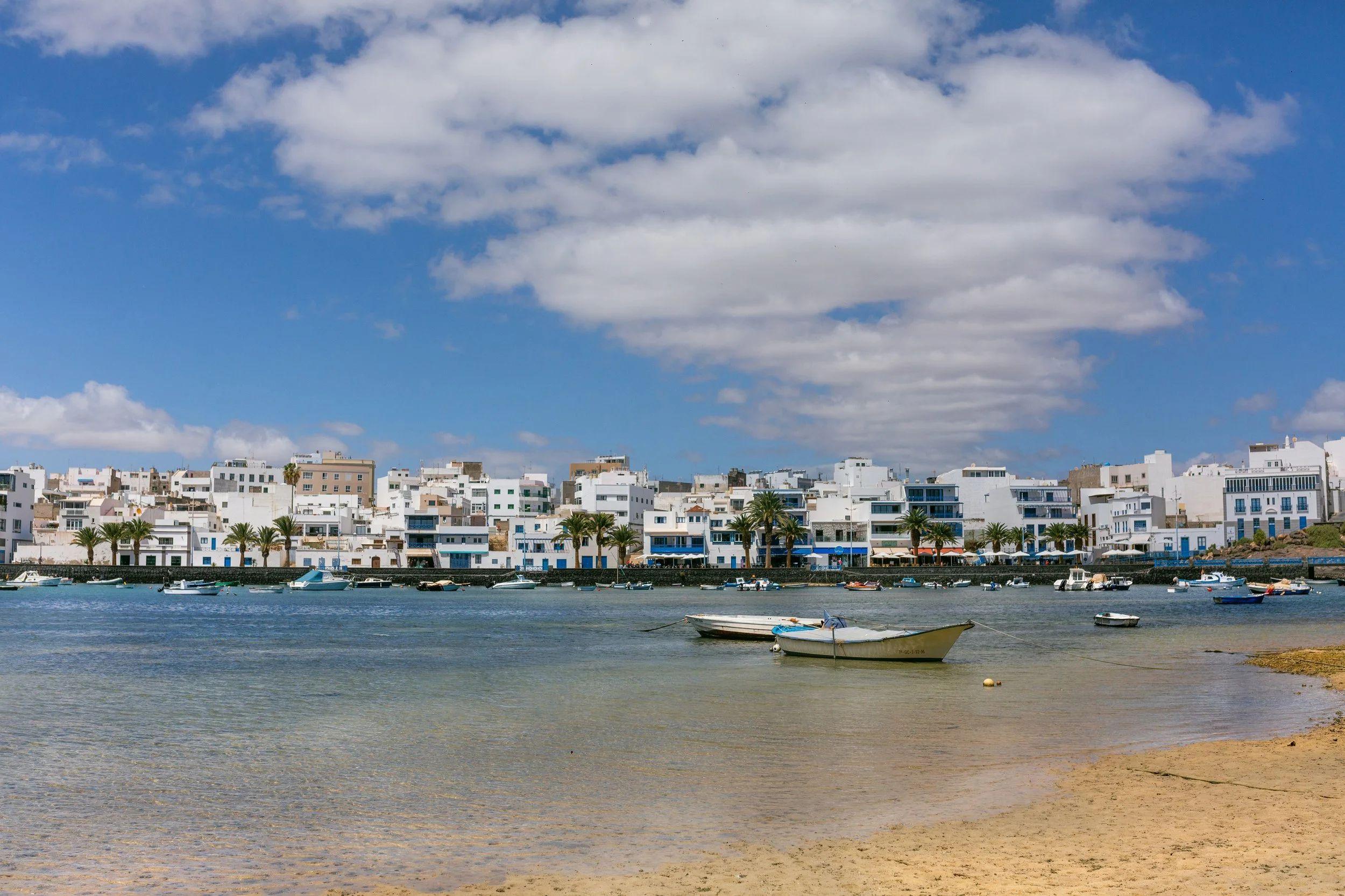 View of the Charco de San Ginés lagoon in Arrecife with fishing boats and white buildings