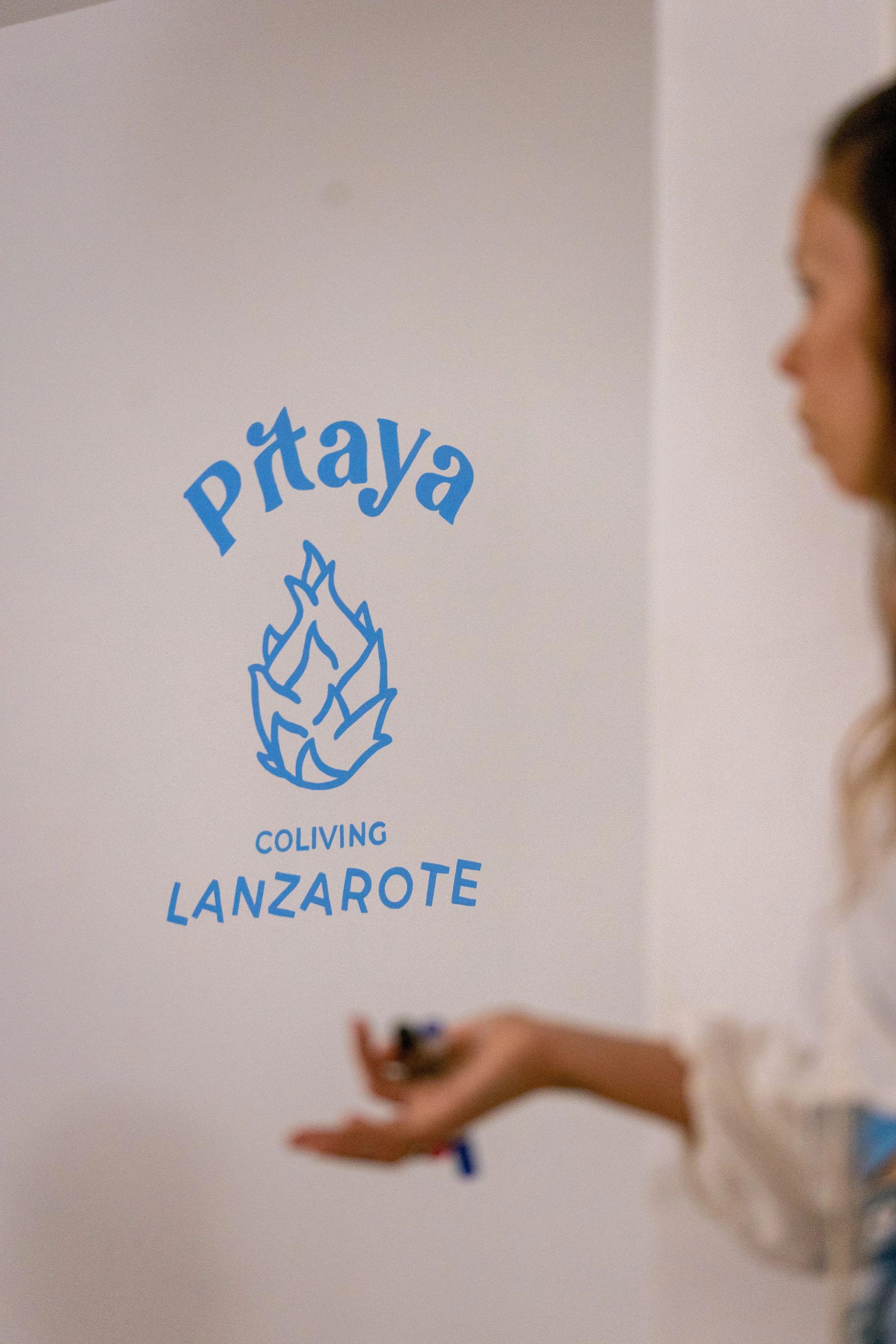 Pitaya Coliving Lanzarote logo painted on the wall with a person in the foreground