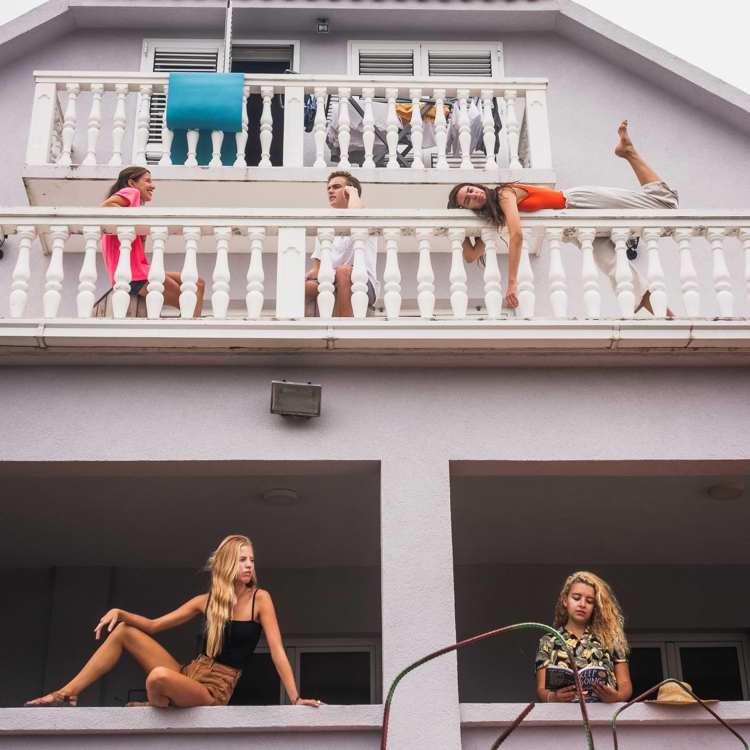Group of residents relaxing and posing on the outdoor balconies of the coliving house