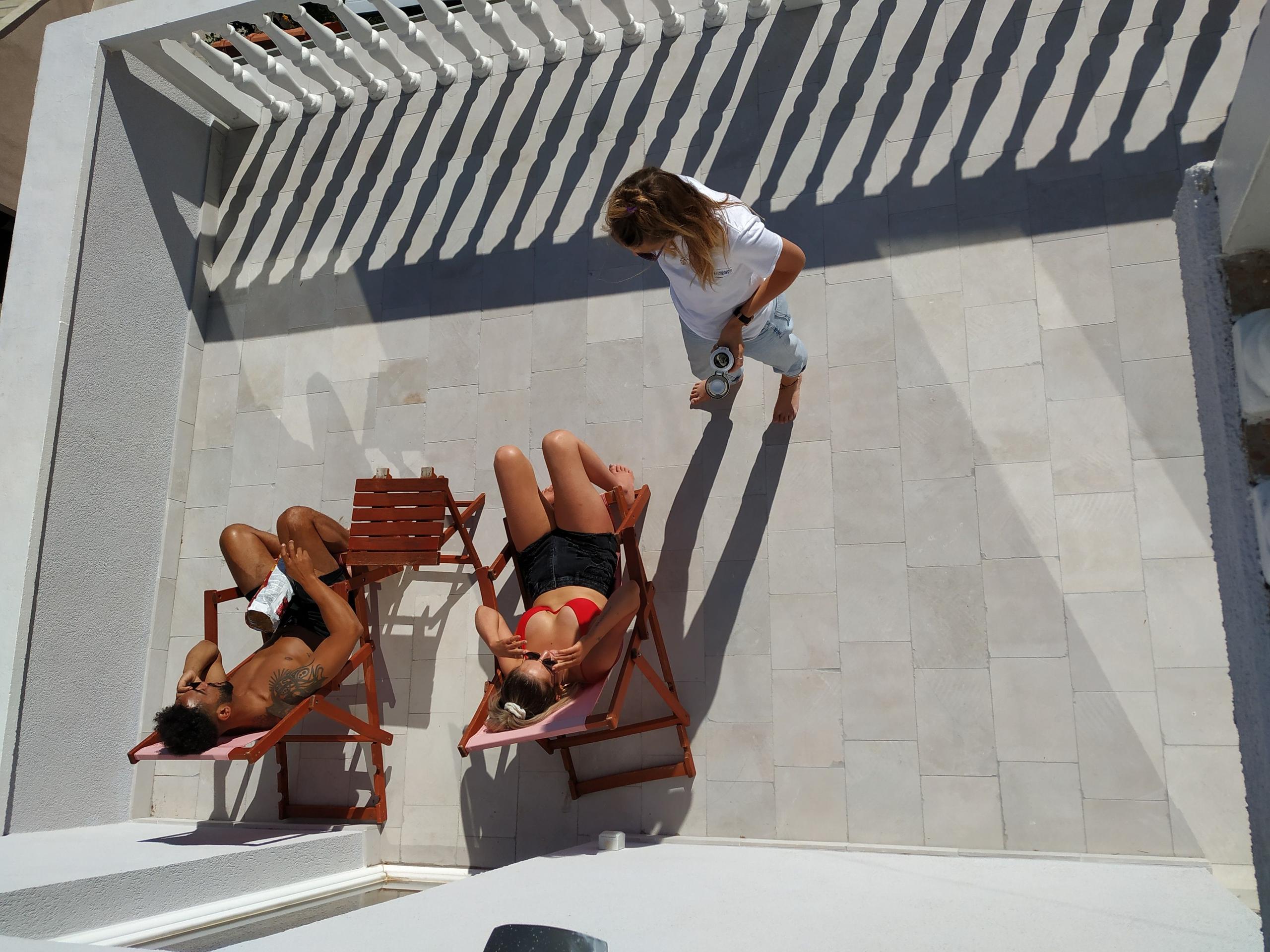 Residents relaxing on sun loungers on the rooftop terrace