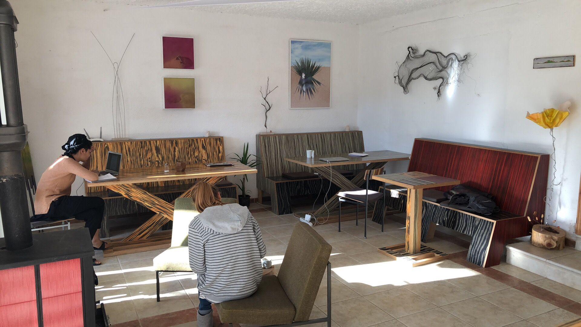 Common area with colorful wooden furniture and residents working on laptops