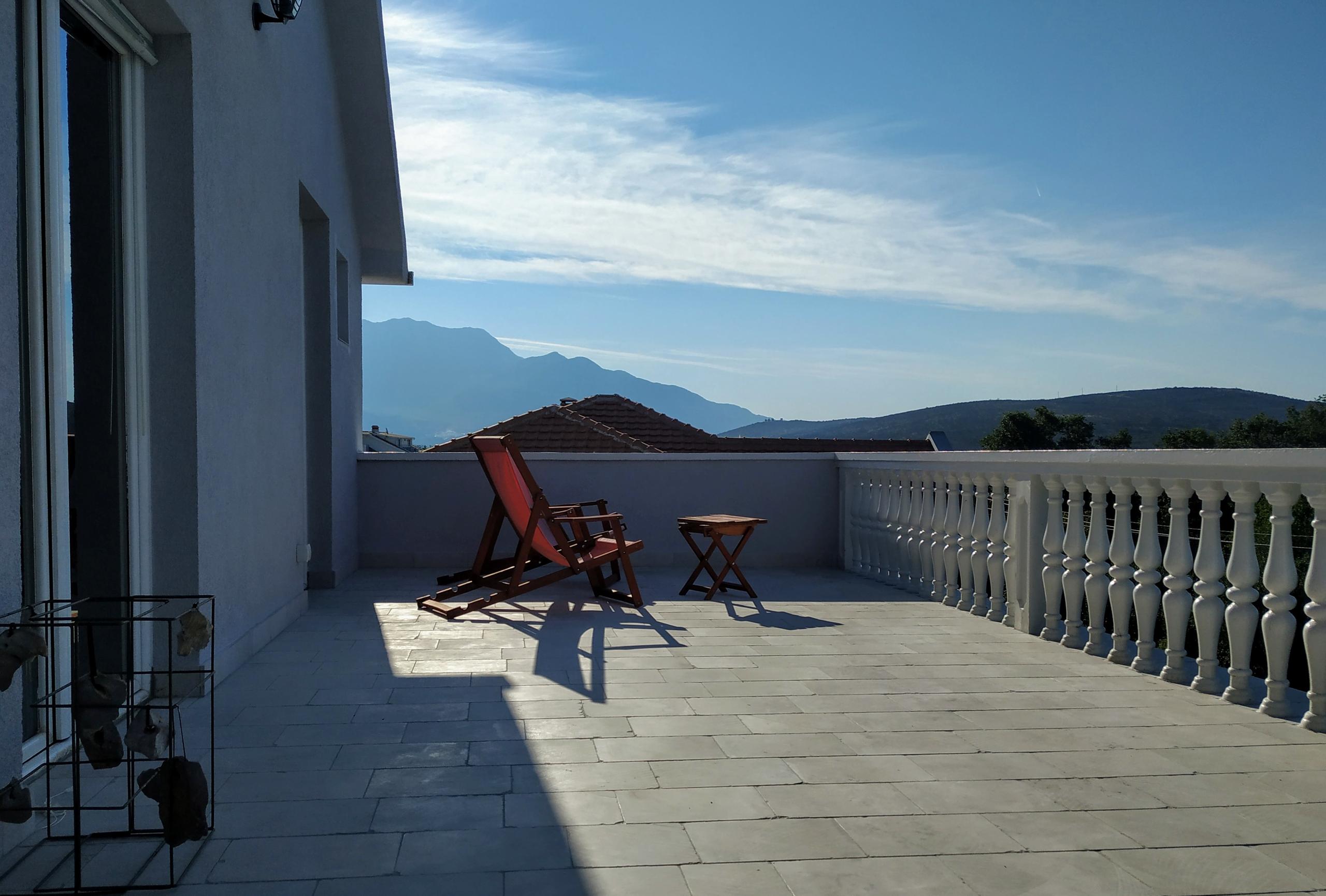 Outdoor balcony with deck chairs and a view of the mountains and surrounding landscape