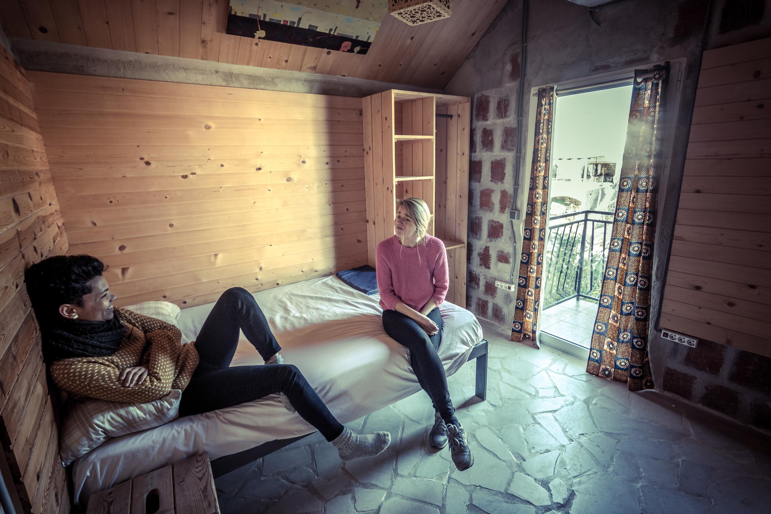 Premium private room with wooden walls, a bed, and a balcony door