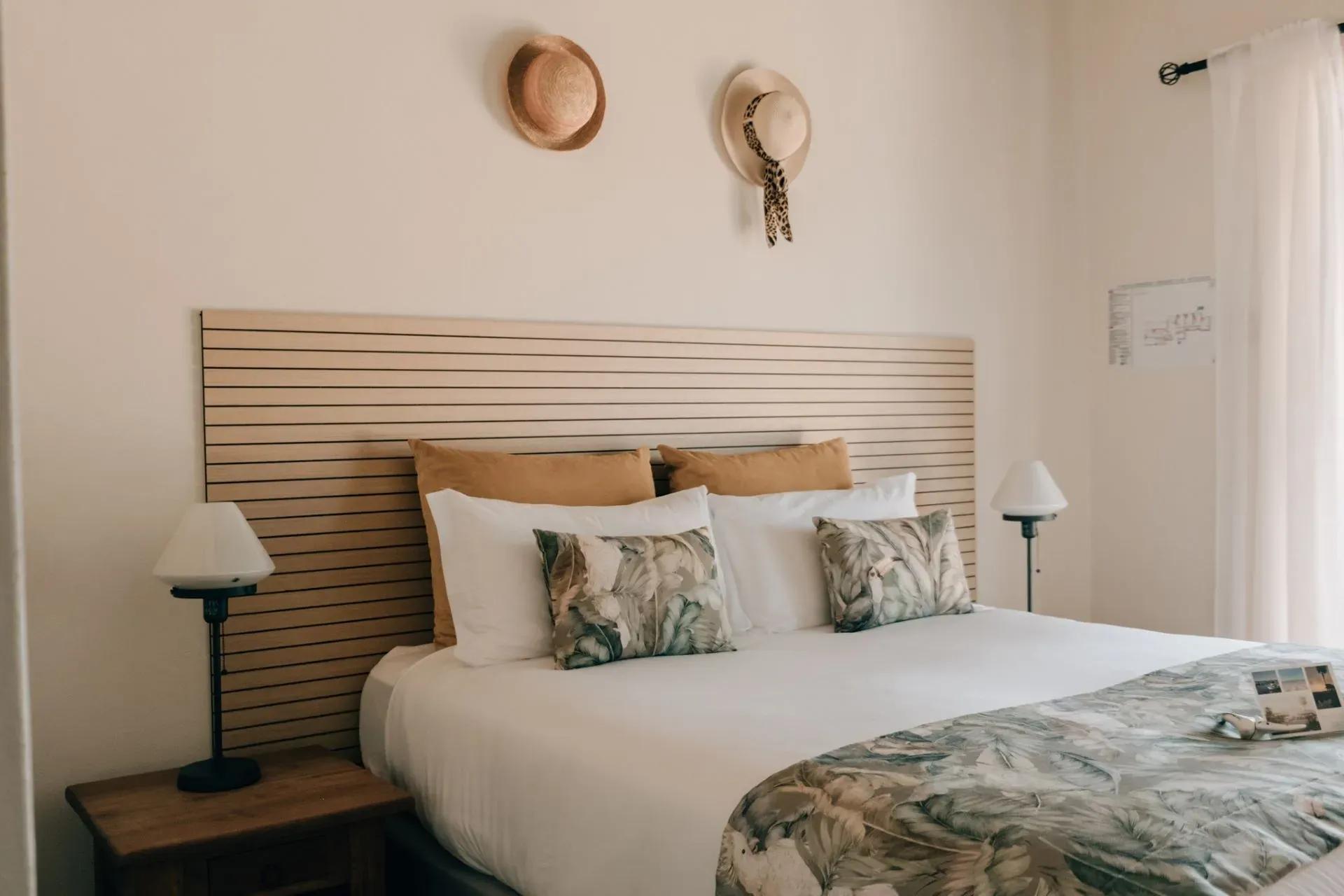 Stylish suite bedroom at POMAR na praia with queen-size bed, natural tones, and decorative pillows.
