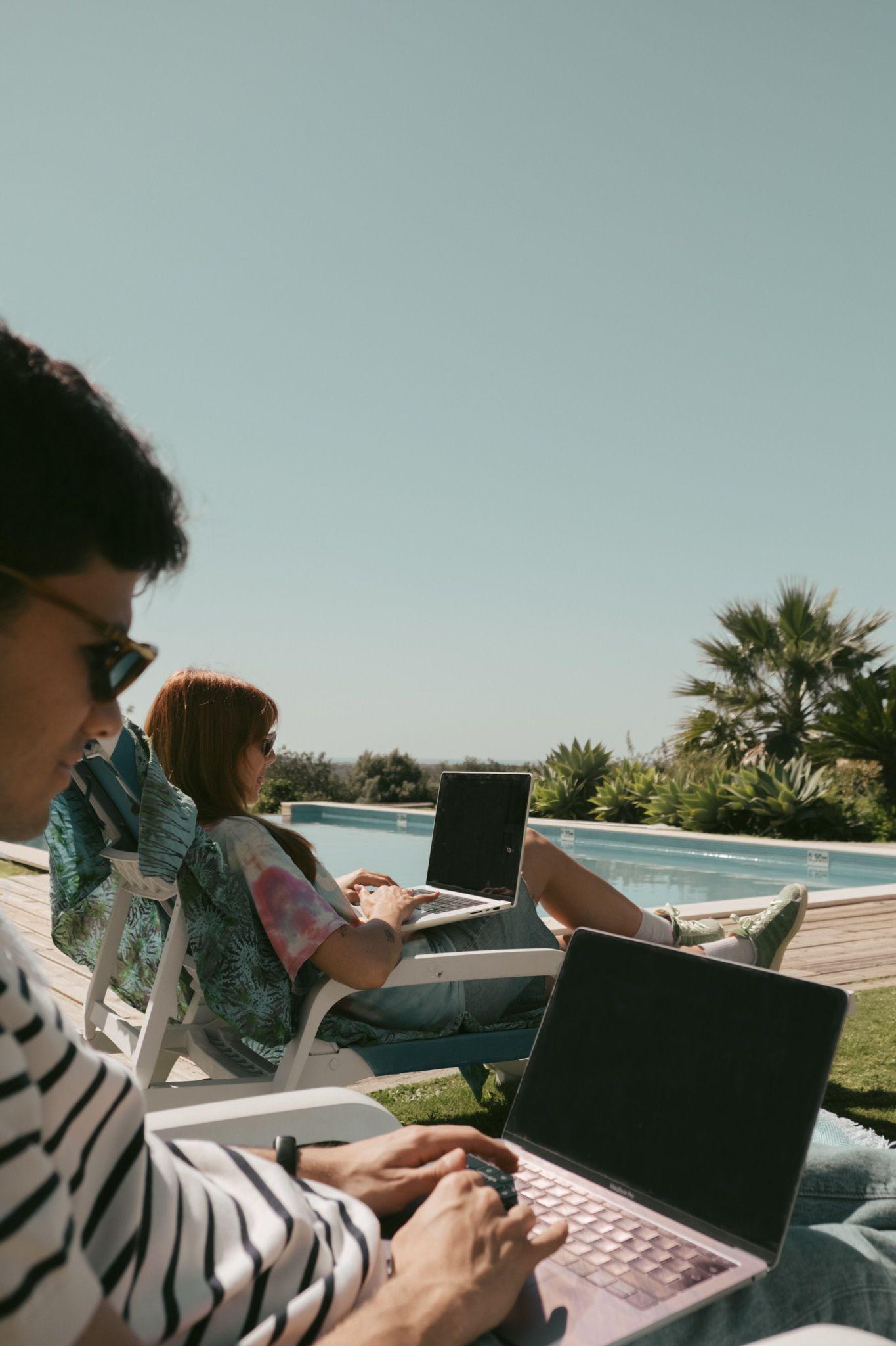 Digital nomads working by the pool at POMAR Coliving