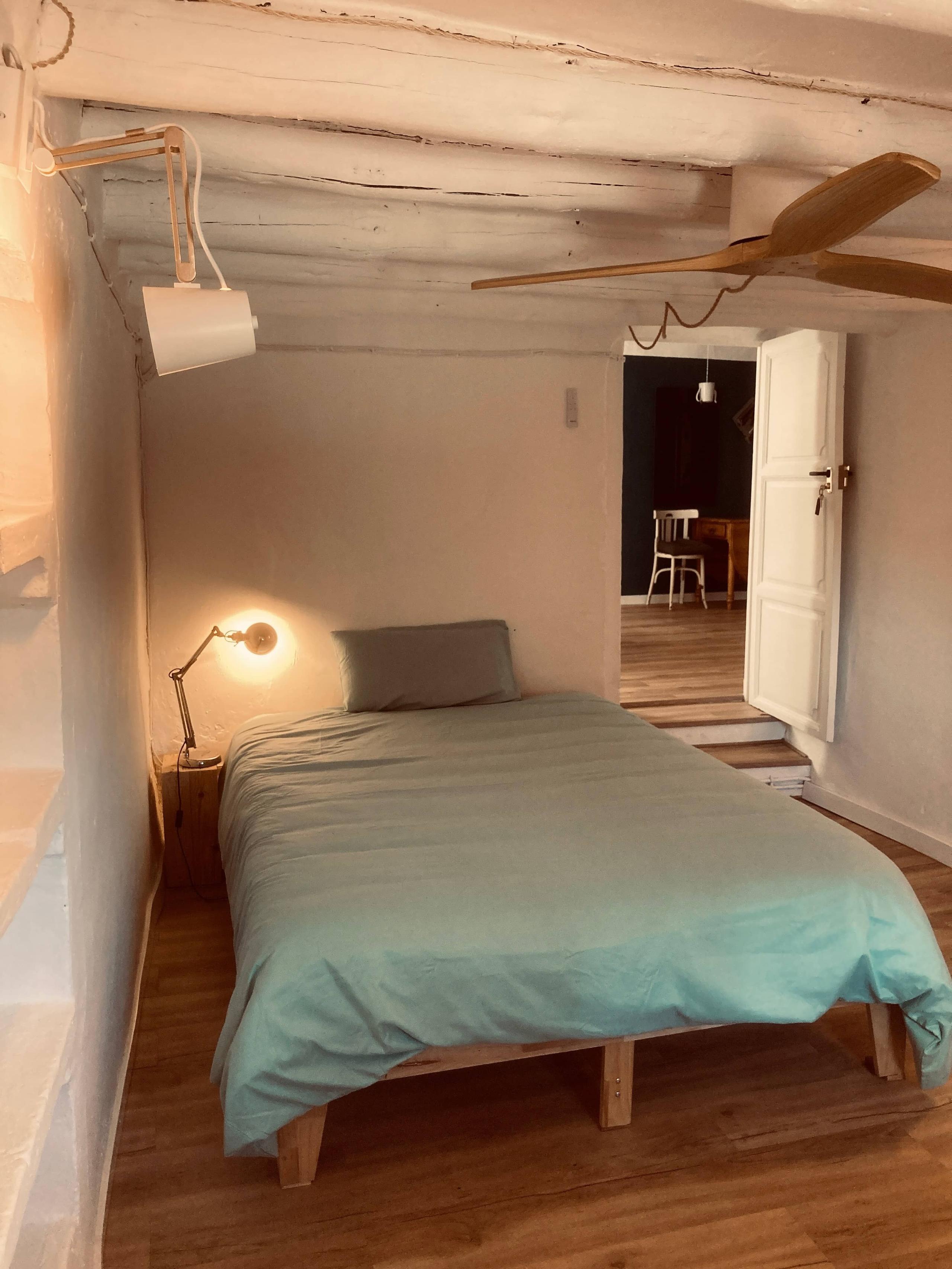 The Arbus room at Posada de la Luz showing the bed, nightstand, lamp and door