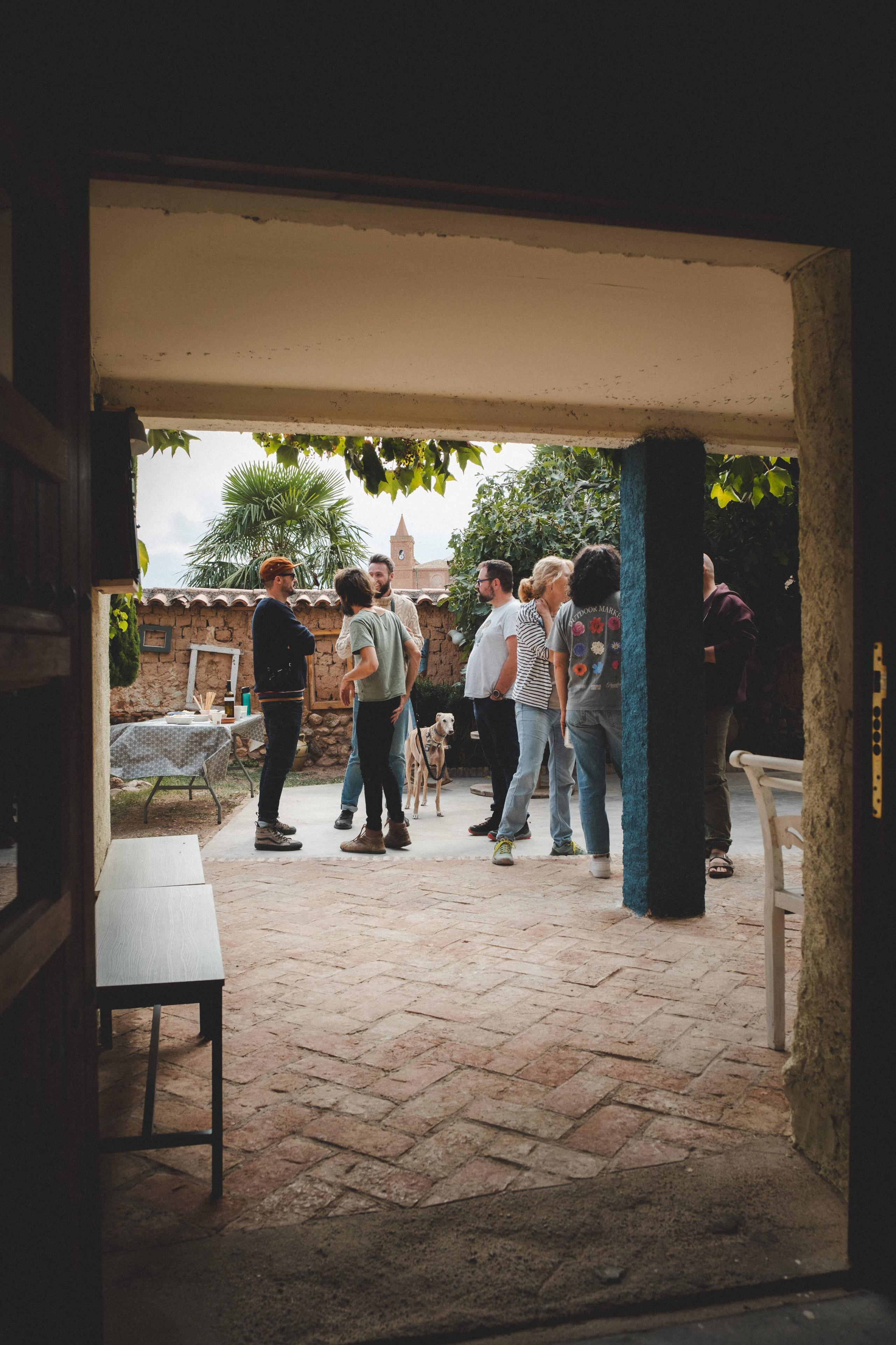 Group of people at Posada de la Luz conversing outside in a sunny courtyard