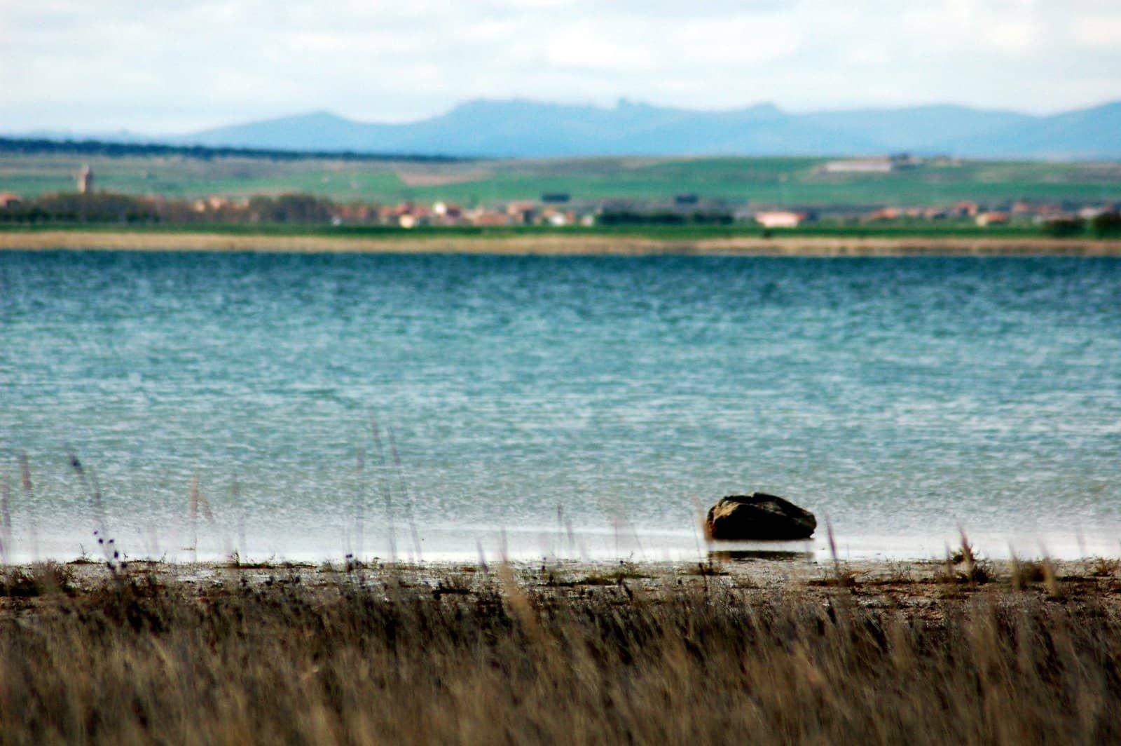 Panoramic view of Laguna de Gallocanta lake with a village in the background and mountains