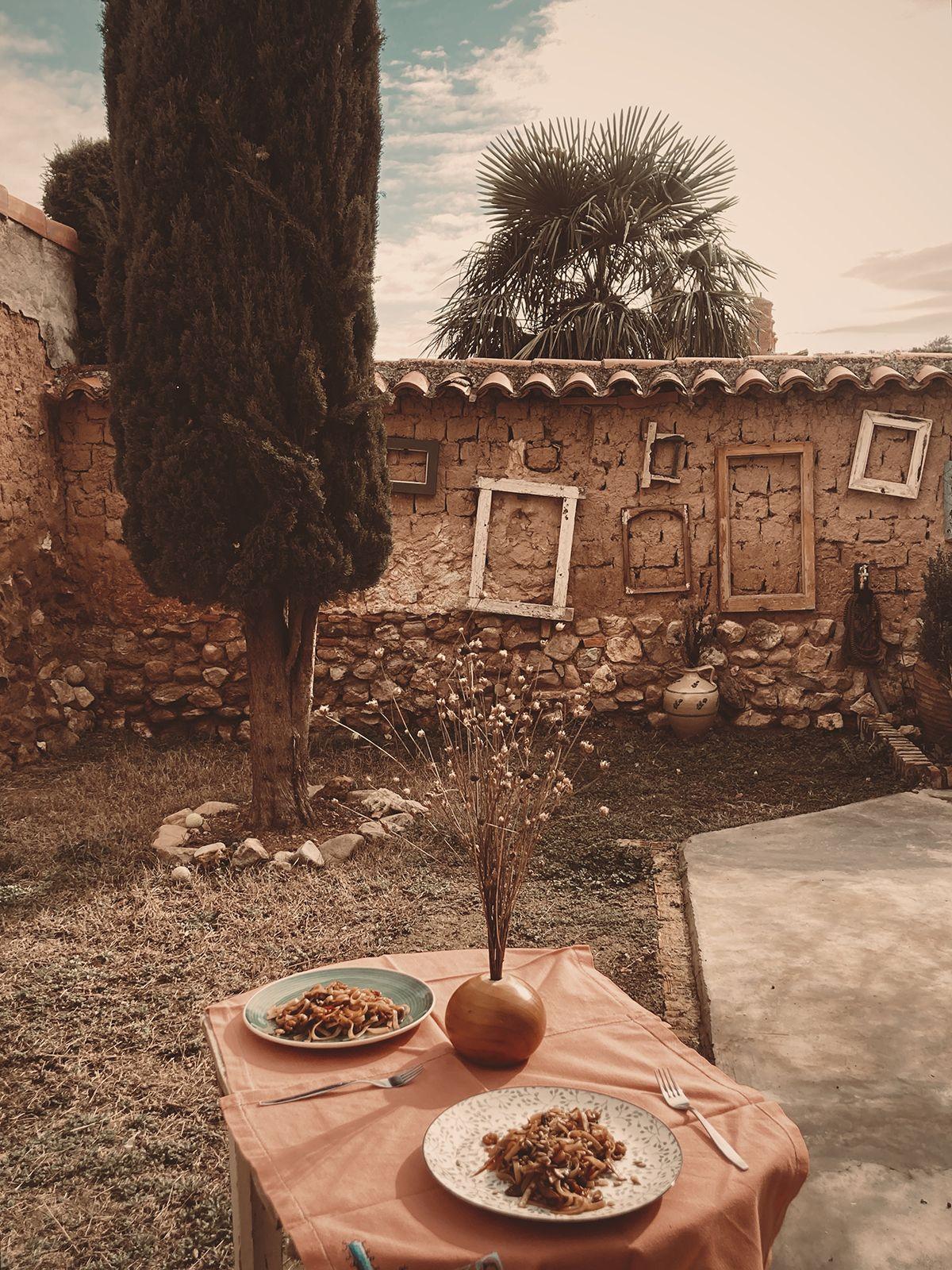 Garden at Posada de la Luz with a table with food in the foreground and a tree in the background
