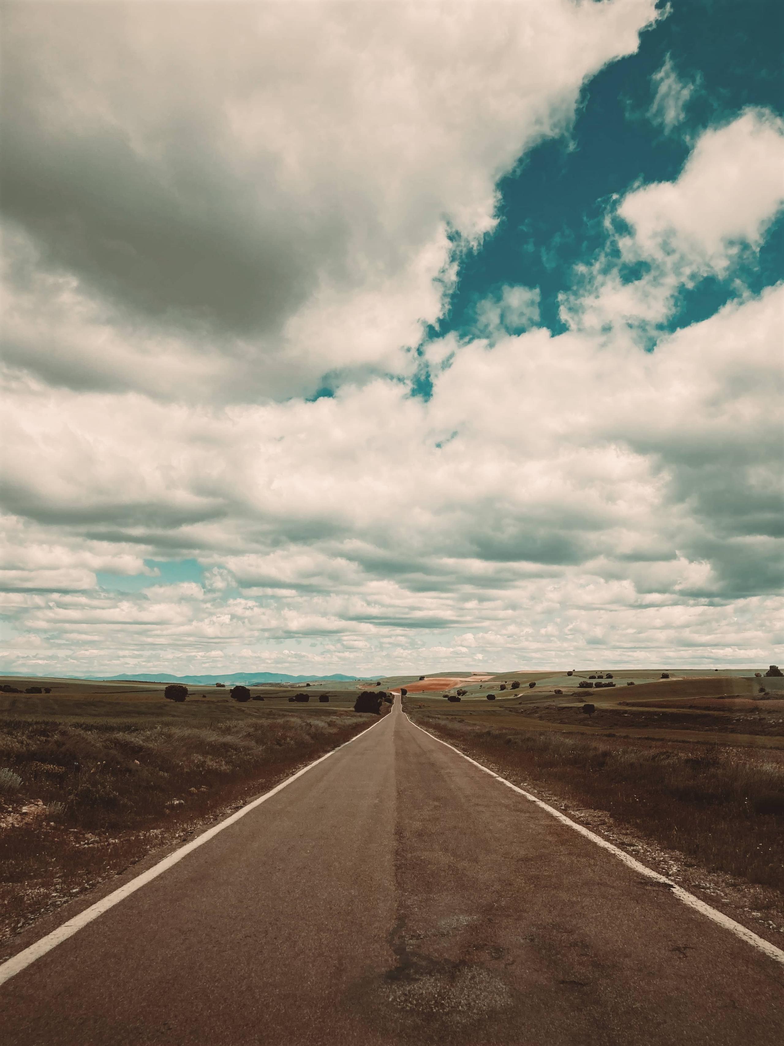Straight road stretching to the horizon with cloudy skies around Posada de la Luz in Torralba de Ribota