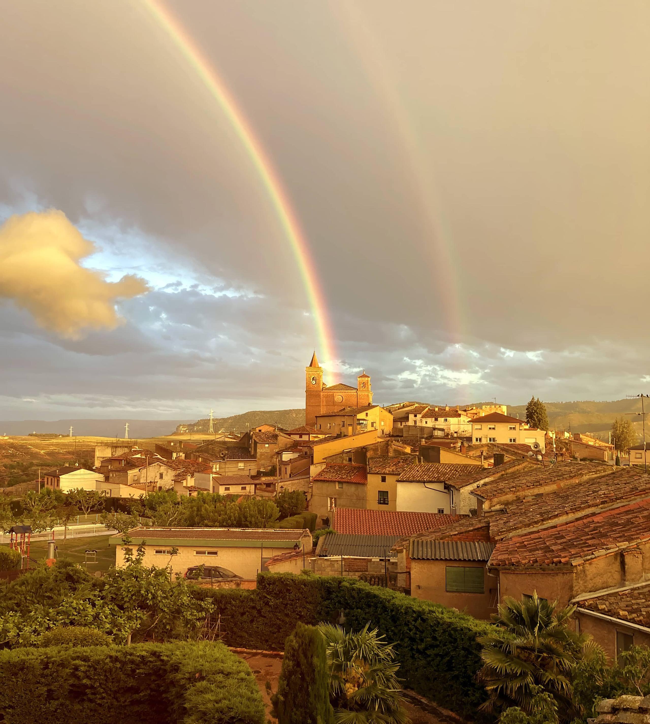 Photograph of part of the village of Torralba de Ribota showing the Church of San Miguel with a rainbow and rooftops