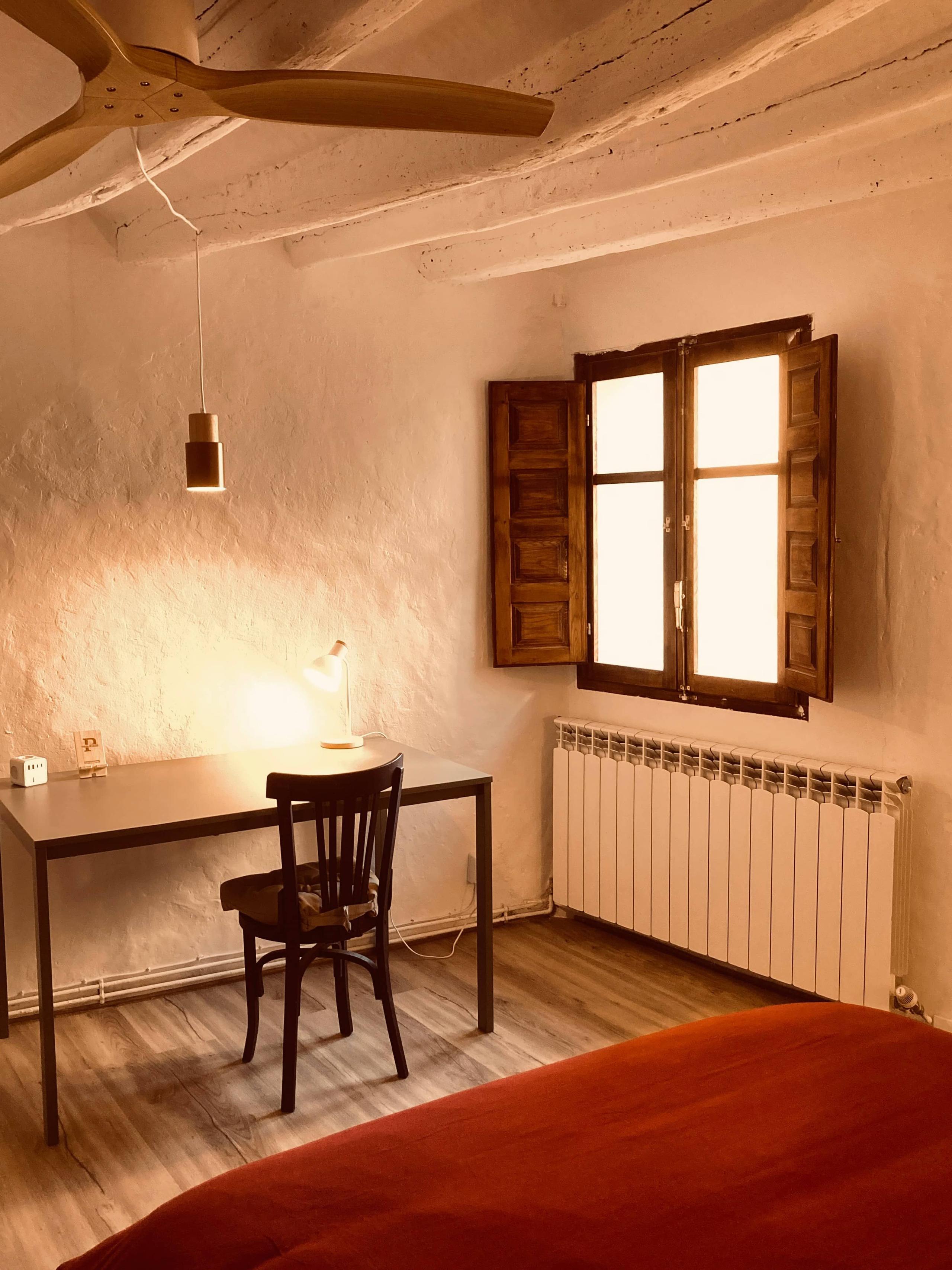 Work desk, chair, desk lamp and street-facing window in La Vivian room