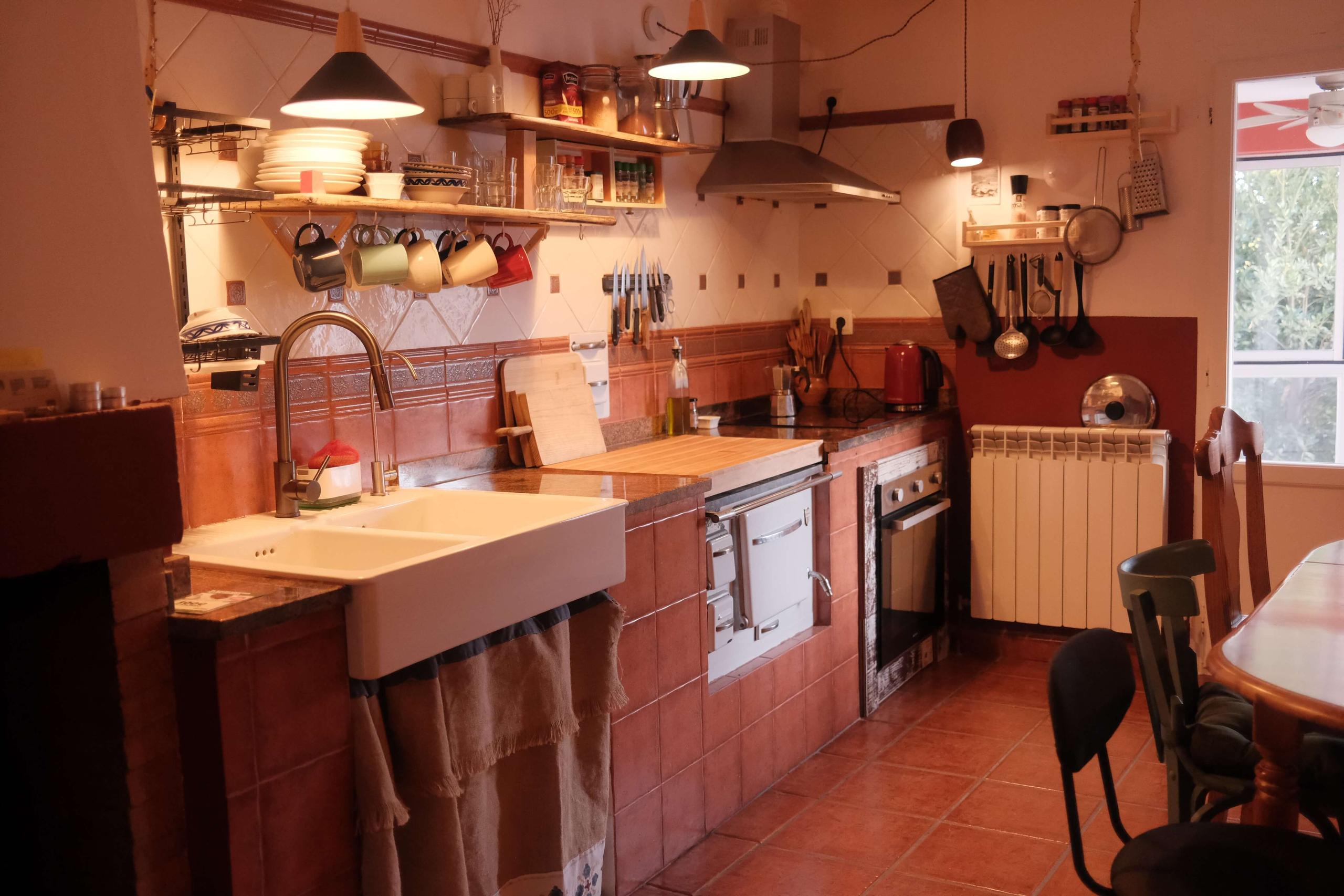Kitchen with red bricks, stove and sink; charming rustic design at Posada de la Luz