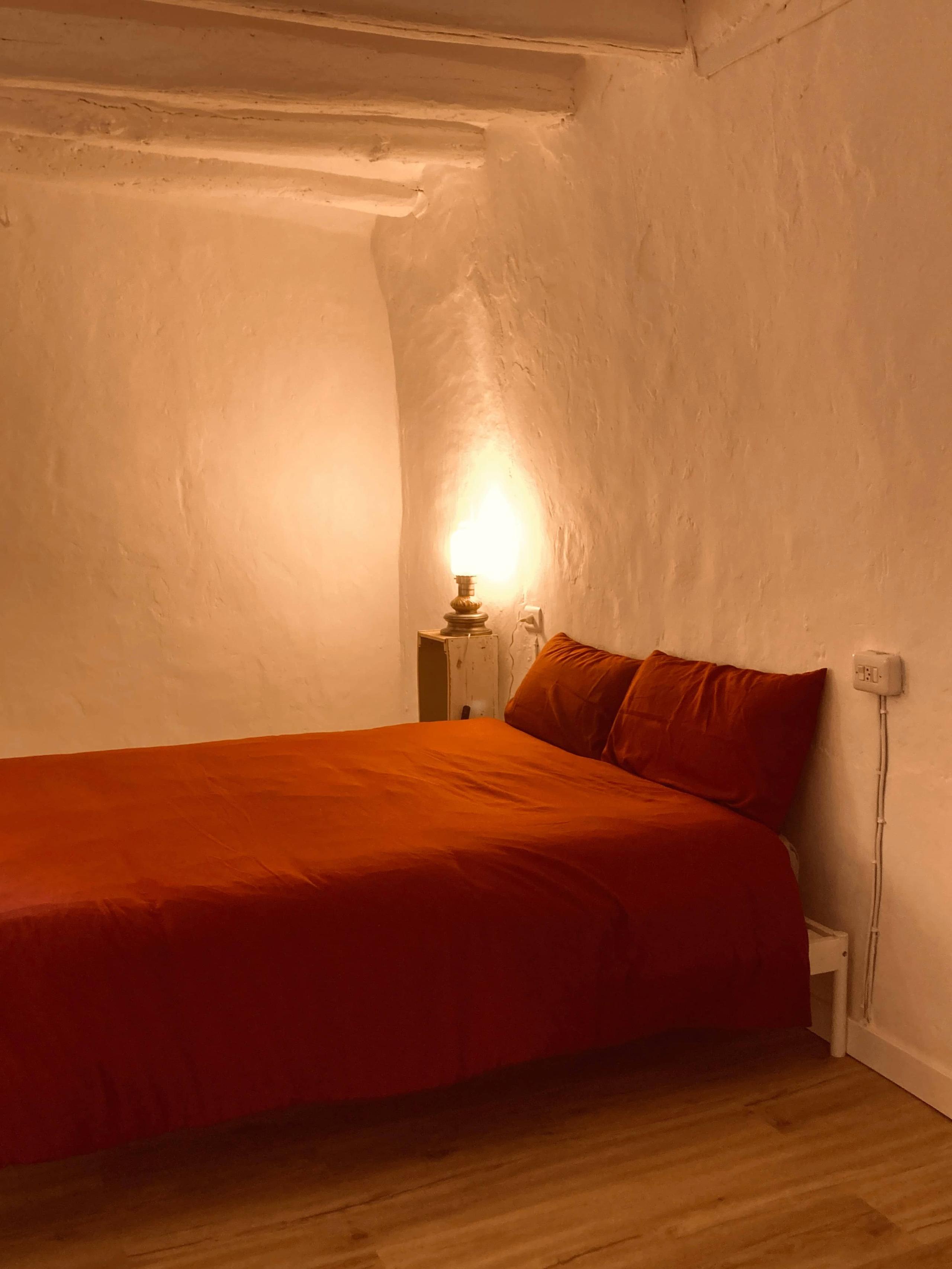 Bed and nightstand with night lamp in La Vivian room