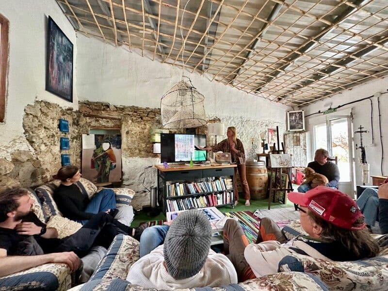 Group of residents gathered in the living room for a presentation or workshop, with a host presenting at the front