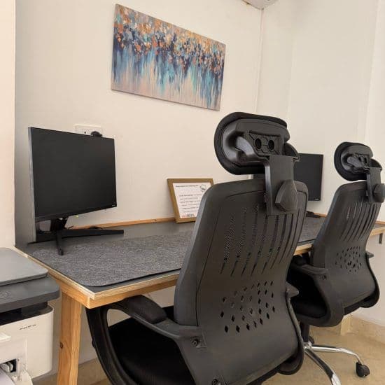 Indoor coworking workstation with 20-inch monitor and ergonomic office chairs