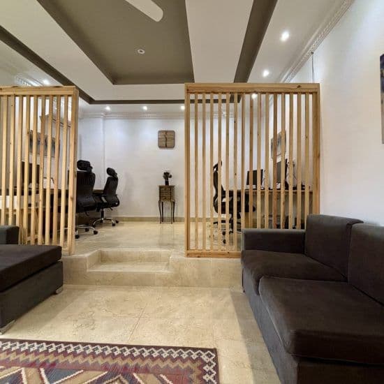 Indoor coworking area showing ergonomic office chairs and workstations behind wooden slatted dividers