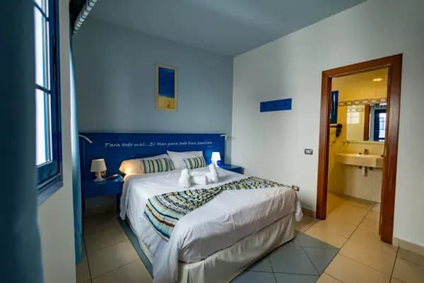 Double bed bedroom with attached bathroom visible through doorway