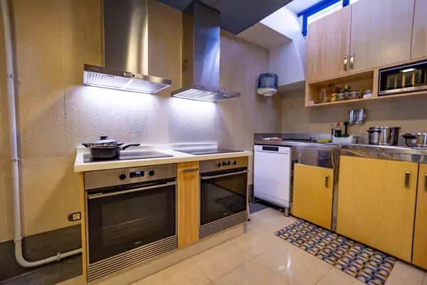Communal kitchen with stovetops, ovens and cabinetry