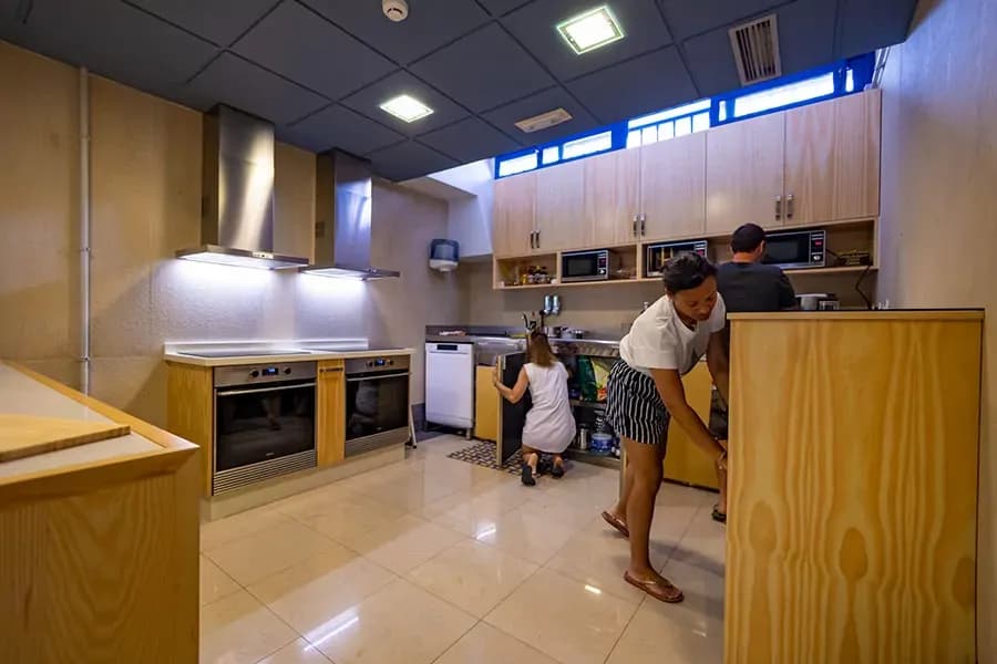 People using the communal kitchen with wooden cabinetry