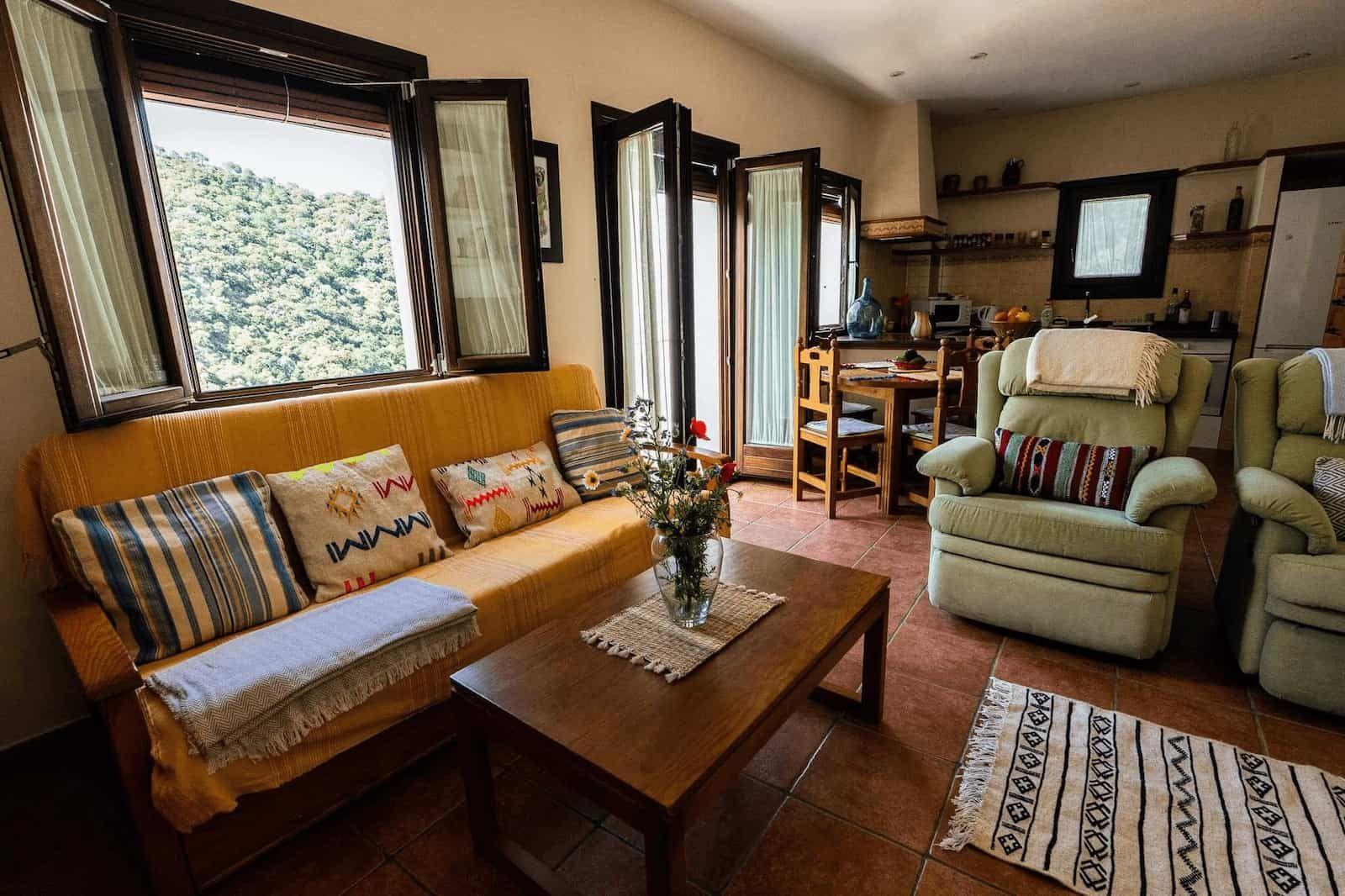 Bright and spacious living room with large windows and open kitchen in Rooral coliving house near Malaga, Spain