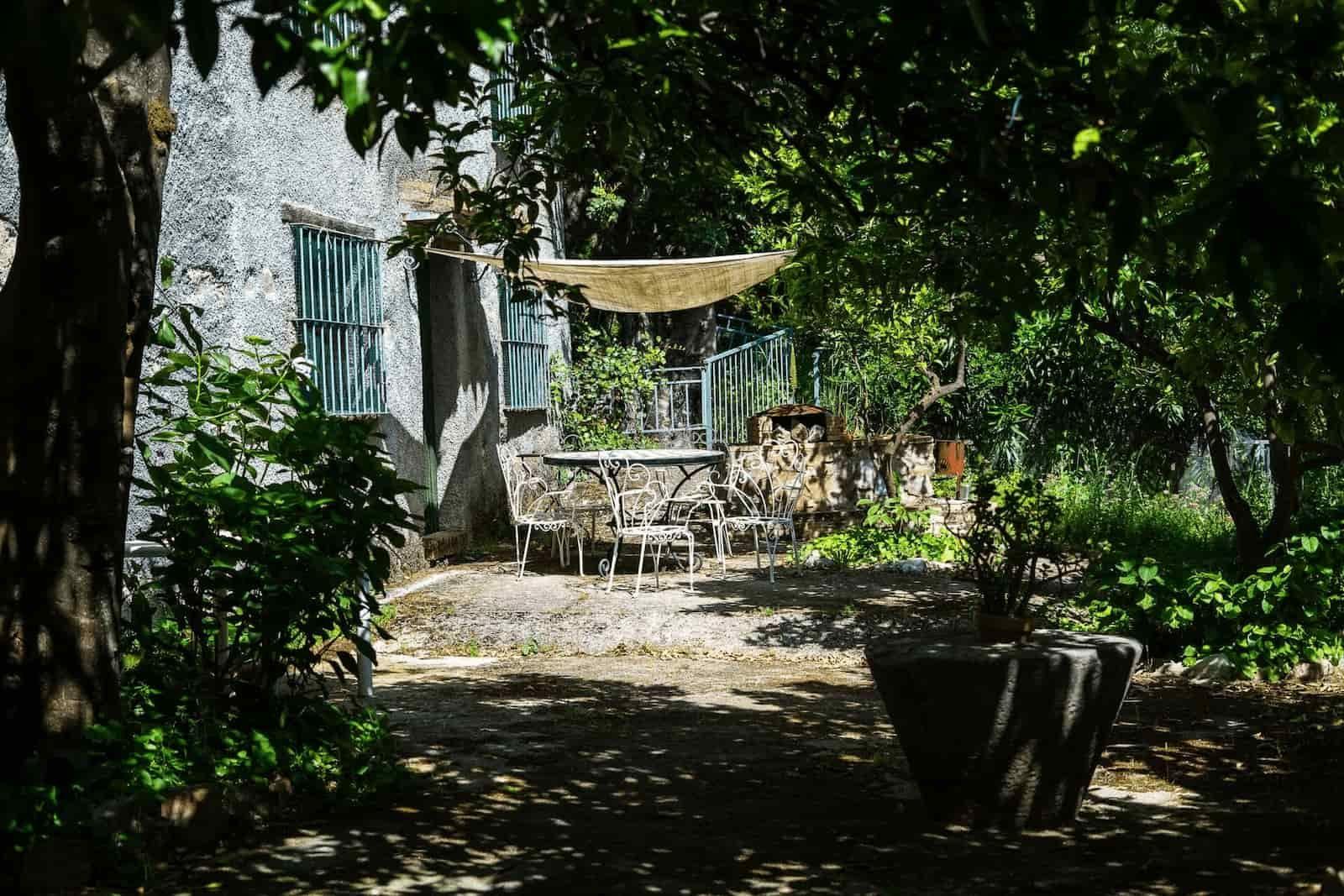Outdoor garden with table and shadow of Rooral coliving home near Malaga, Spain, ideal for relaxation and work
