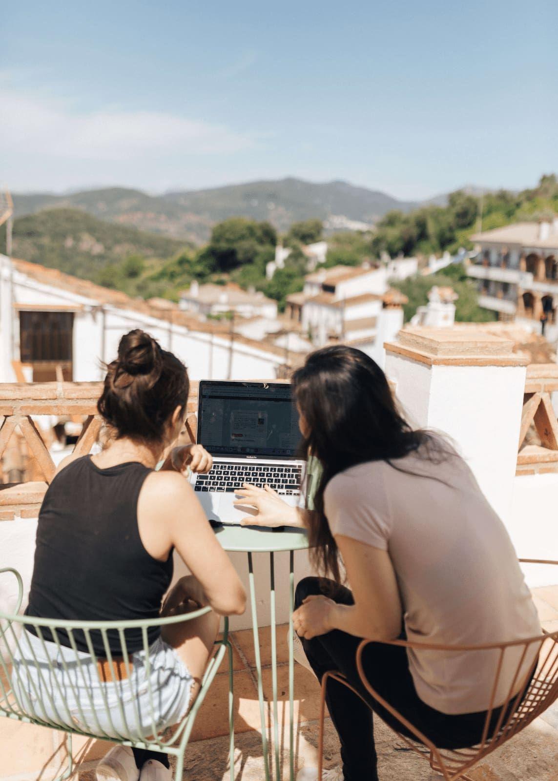 Coworking collaboration at Rooral with village view in the background, rural coworking space in Spain for digital nomads and remote workers