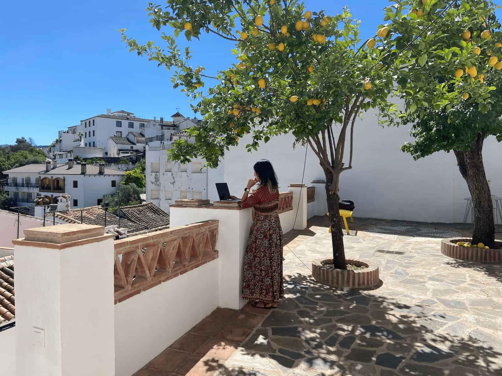 Remote worker on a video call at Rooral coworking terrace under a lemon tree, ideal for digital nomads and rural coworking in Spain