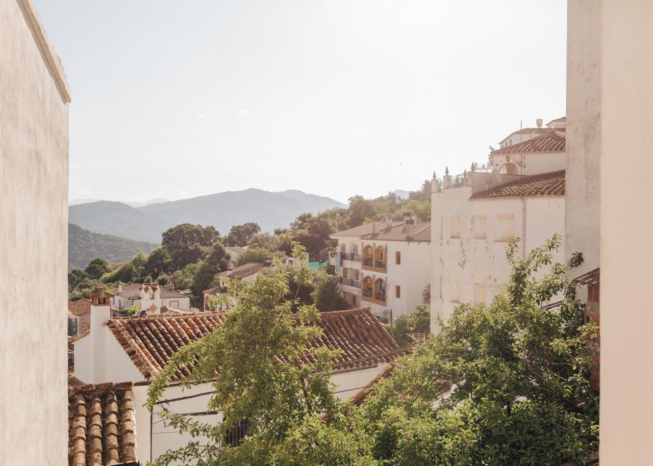 The white Spanish village of Benarrraba in Malaga, with mountains and forests in the background
