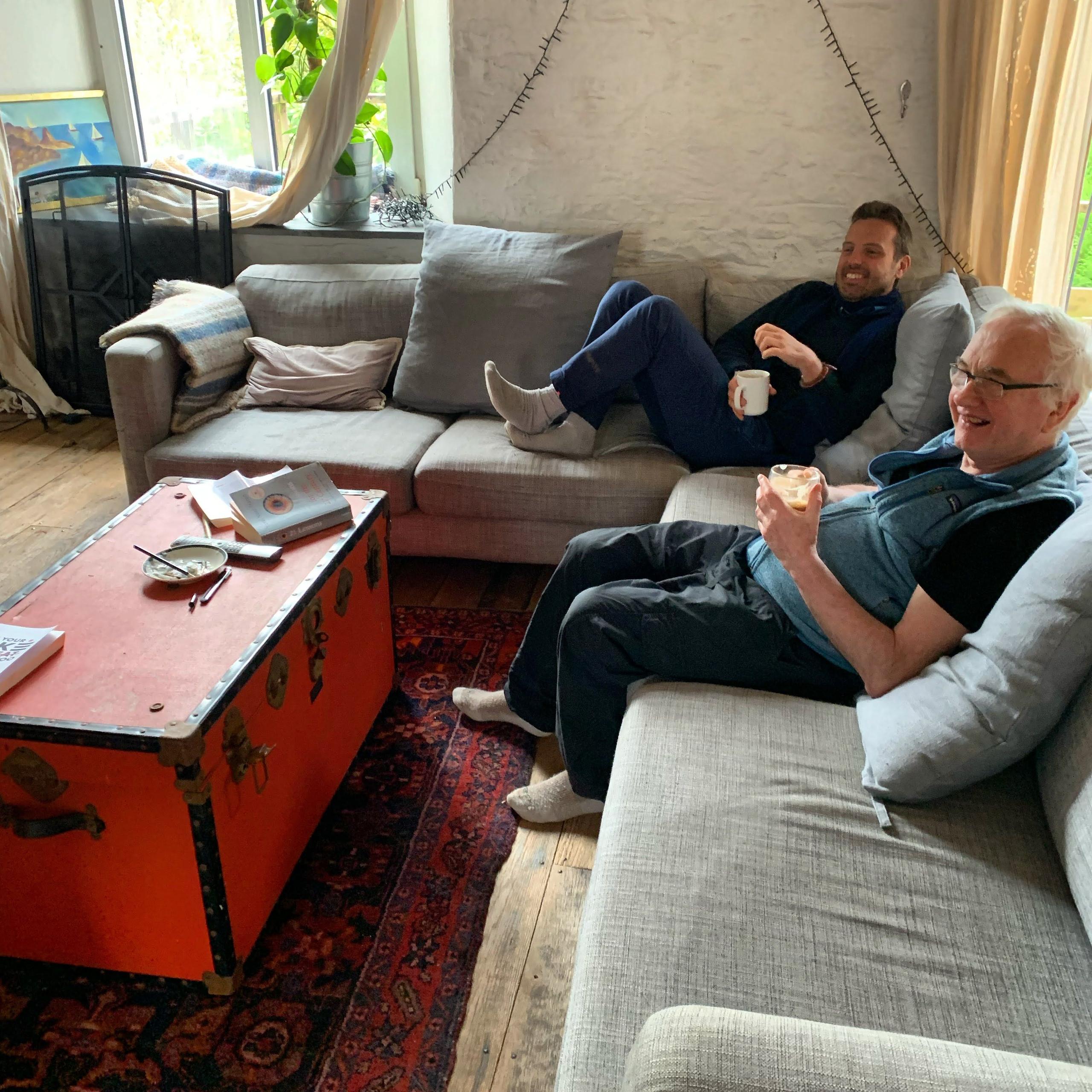 Two colivers relaxing on sofas in the living lounge with a vintage trunk coffee table