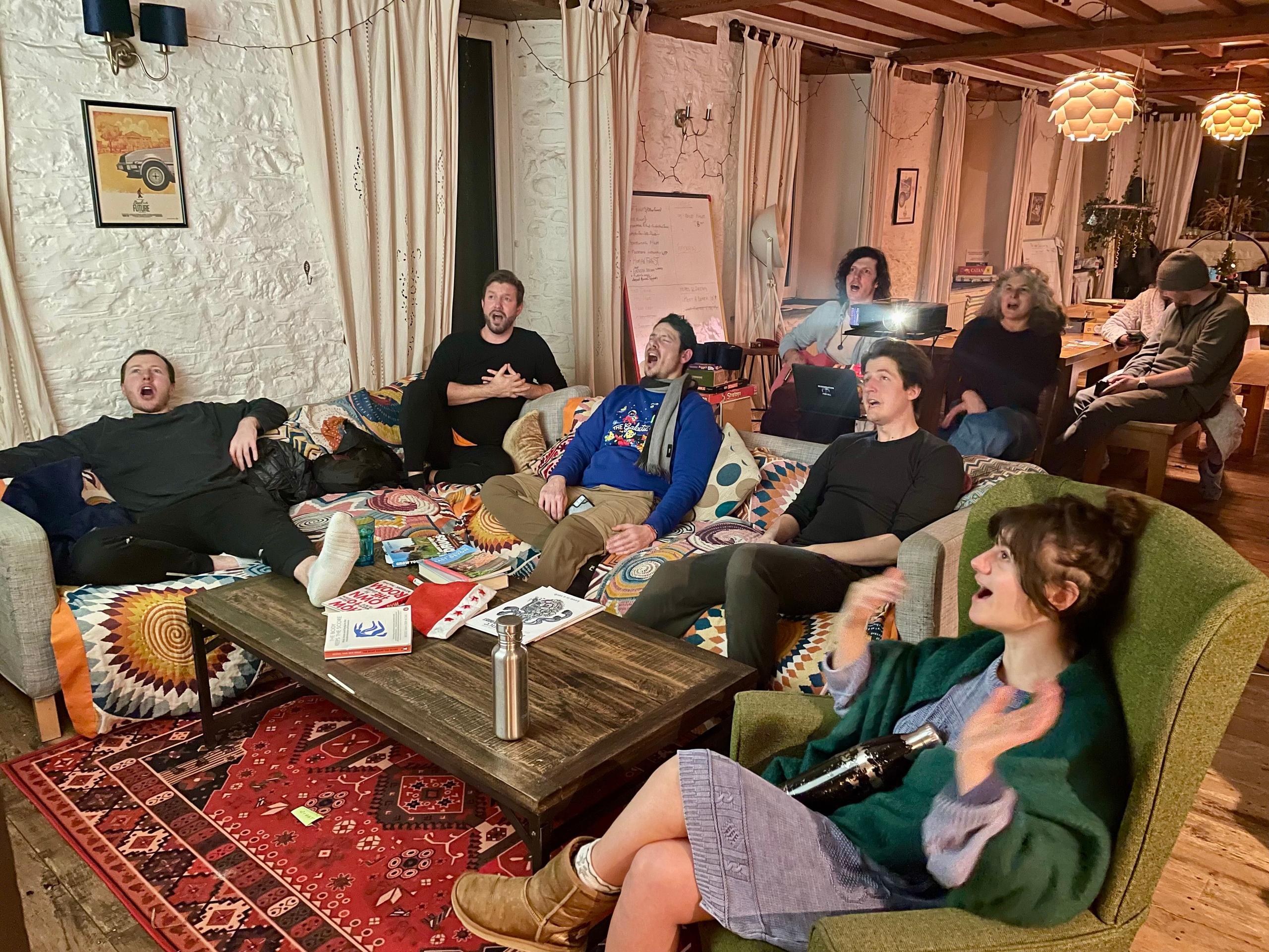 Group of colivers laughing together watching a movie in the living lounge