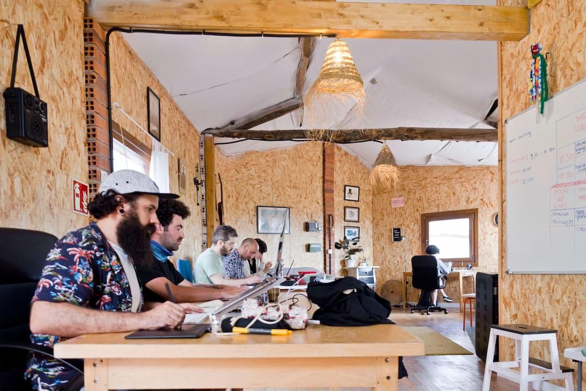 Inside of a coworking space in Sende. Creatives are sitting at different desks and working on their own projects.
