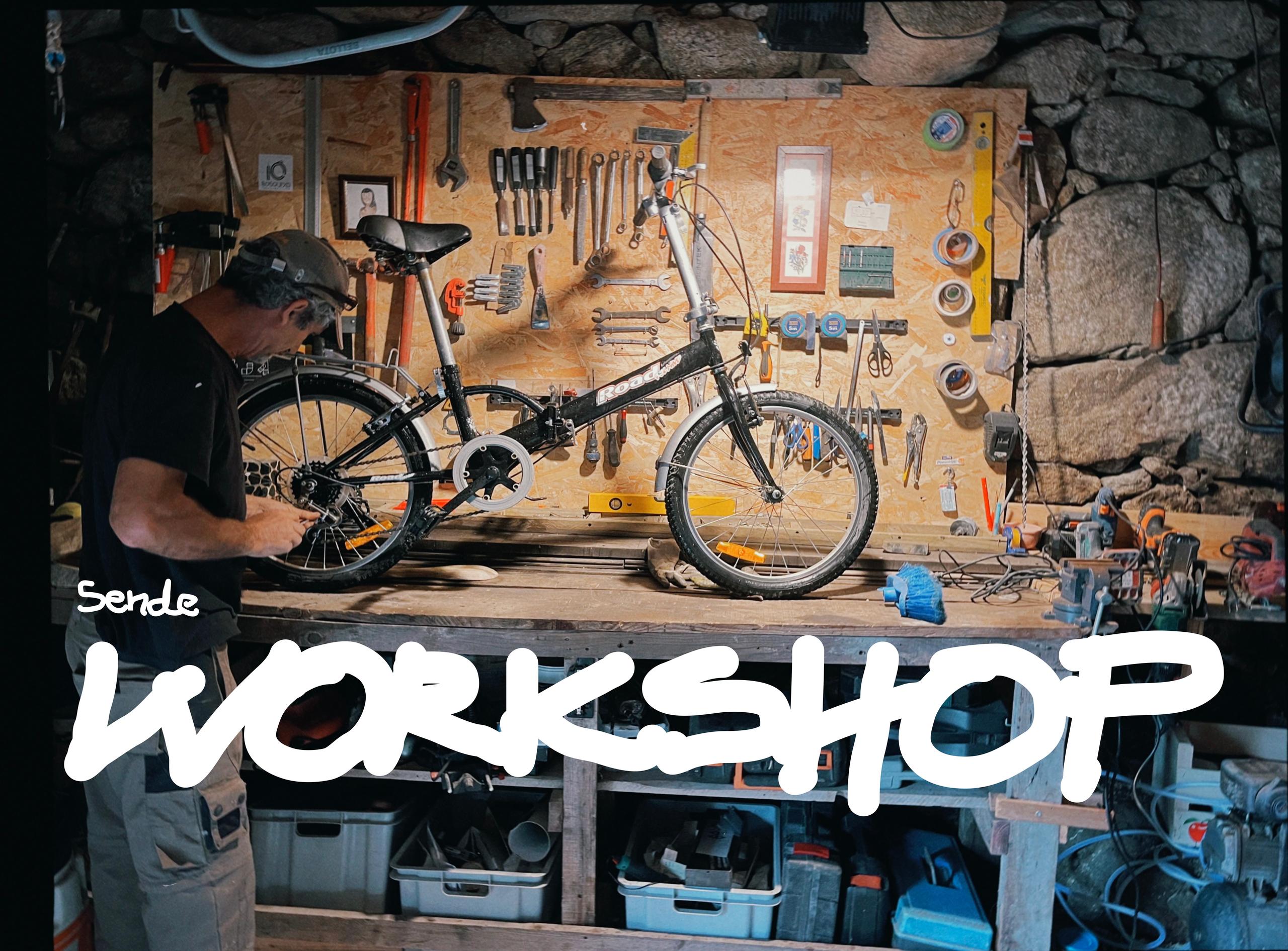 Man working on a bicycle in the Sende tool workshop, with tools organized on the wall behind
