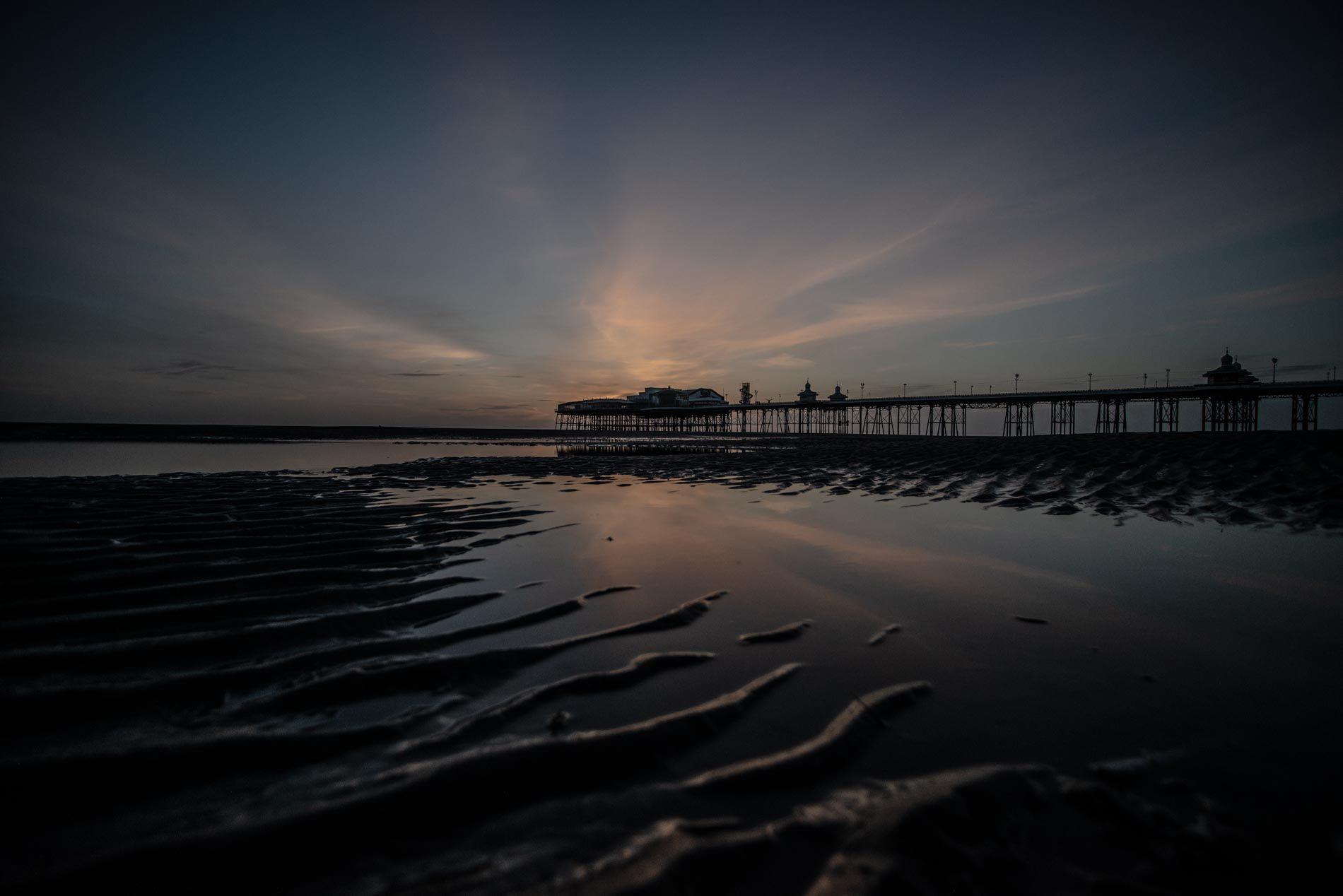 Blackpool North Pier reflected in wet sand at dusk