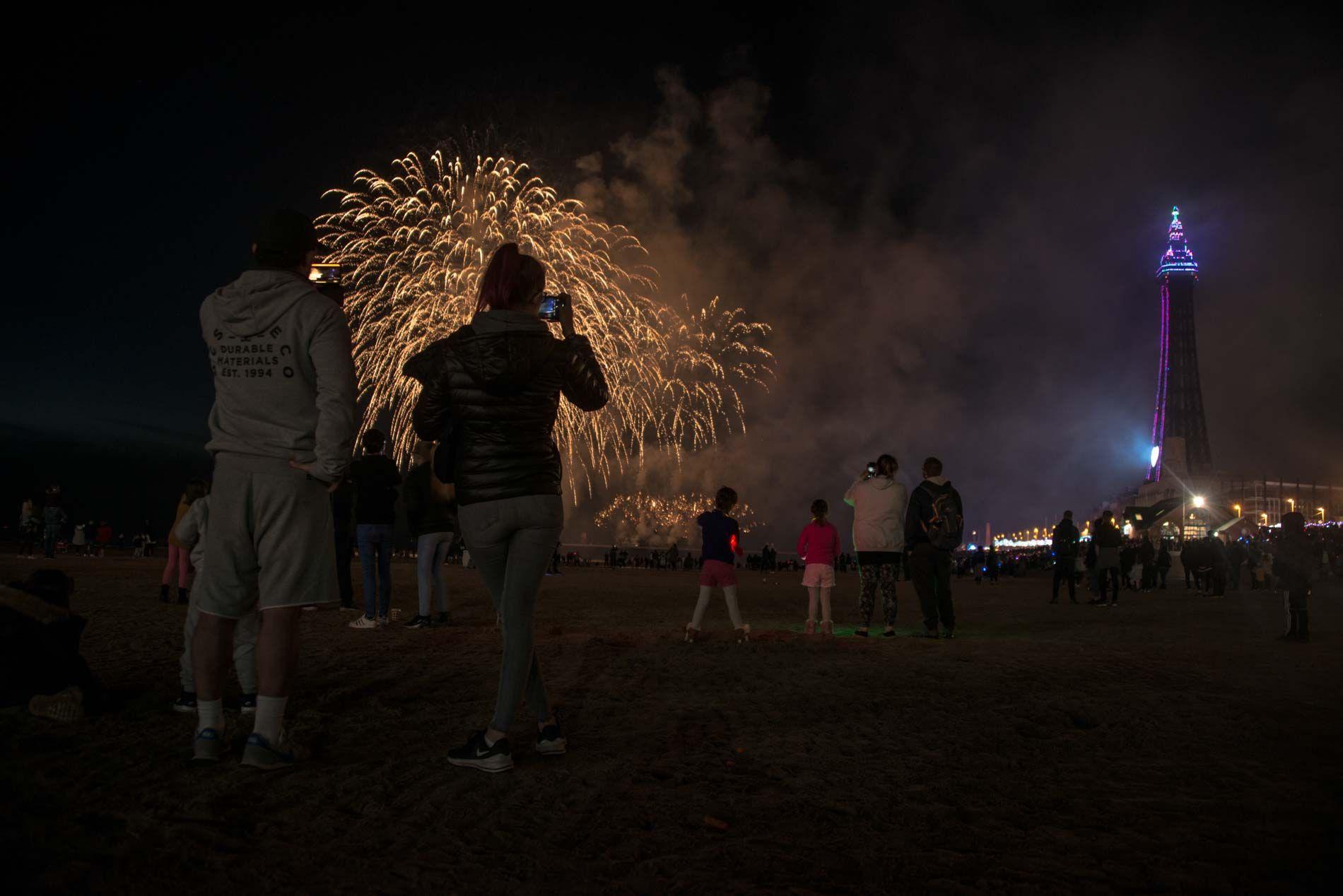 Fireworks display near Blackpool Tower at night with crowd watching