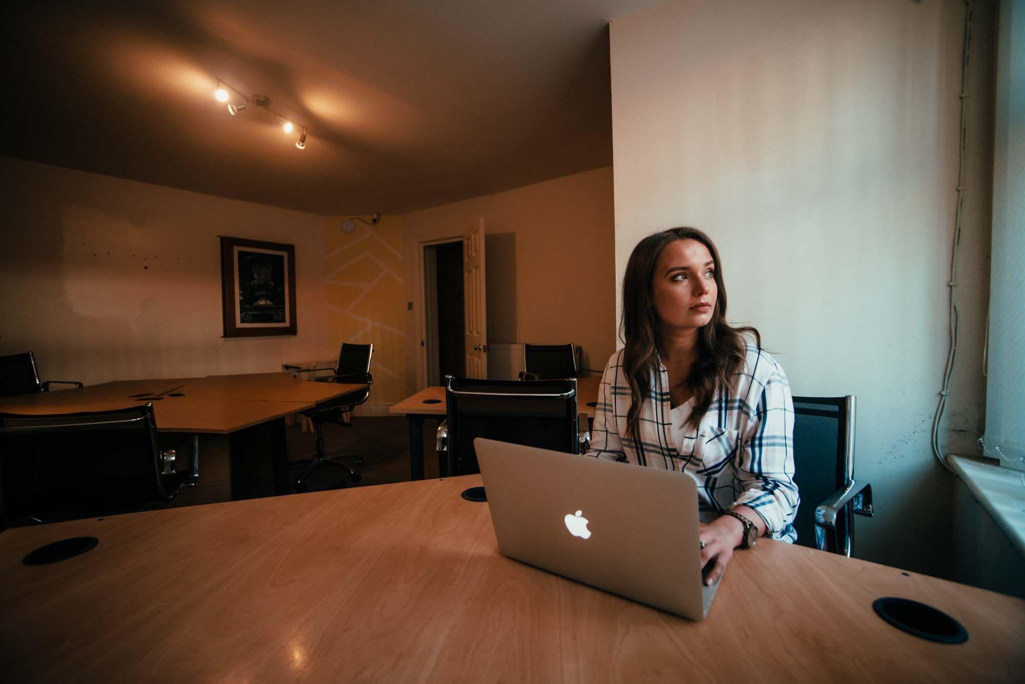 Person working on a MacBook laptop in the quiet coworking room