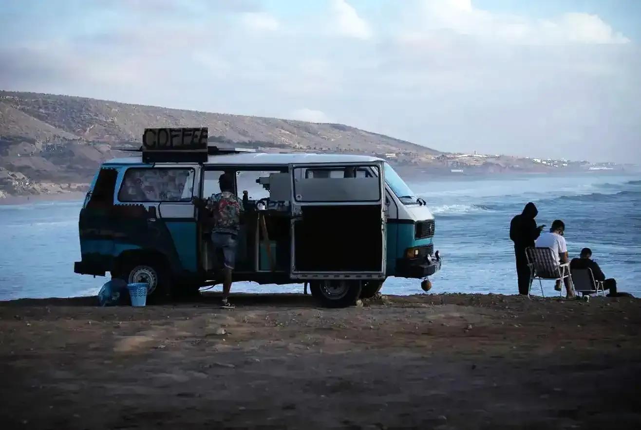 A van parked by Banana Point beach in Taghazout