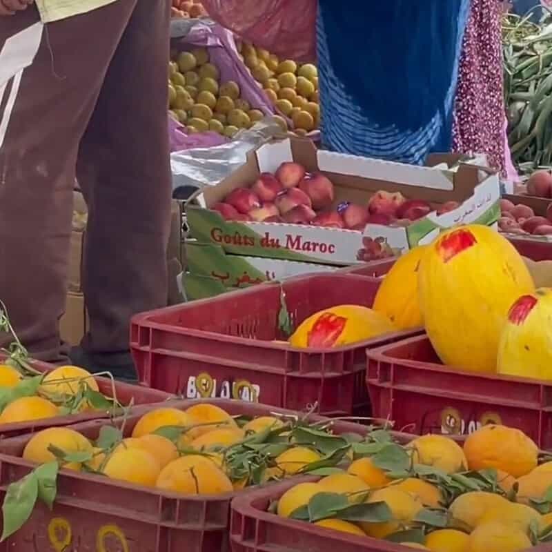 Traditional Moroccan market (souk) in Taghazout with fresh produce, spices, and handcrafted goods