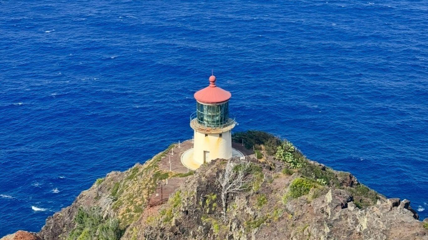 Aerial view of Makapu'u Point Lighthouse on a rocky cliff above the deep blue Pacific Ocean