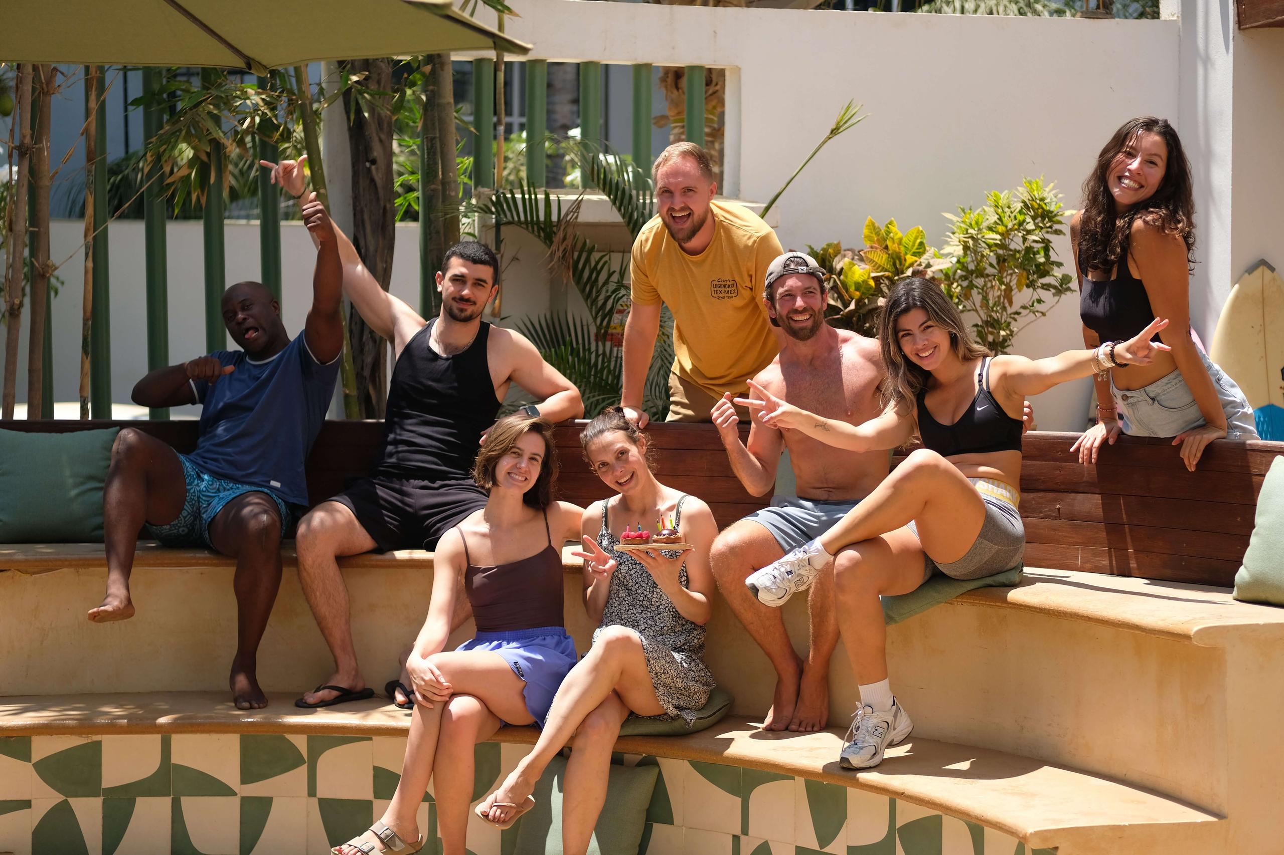 Group of members sitting and socializing by the pool area at Surfbreak PXM
